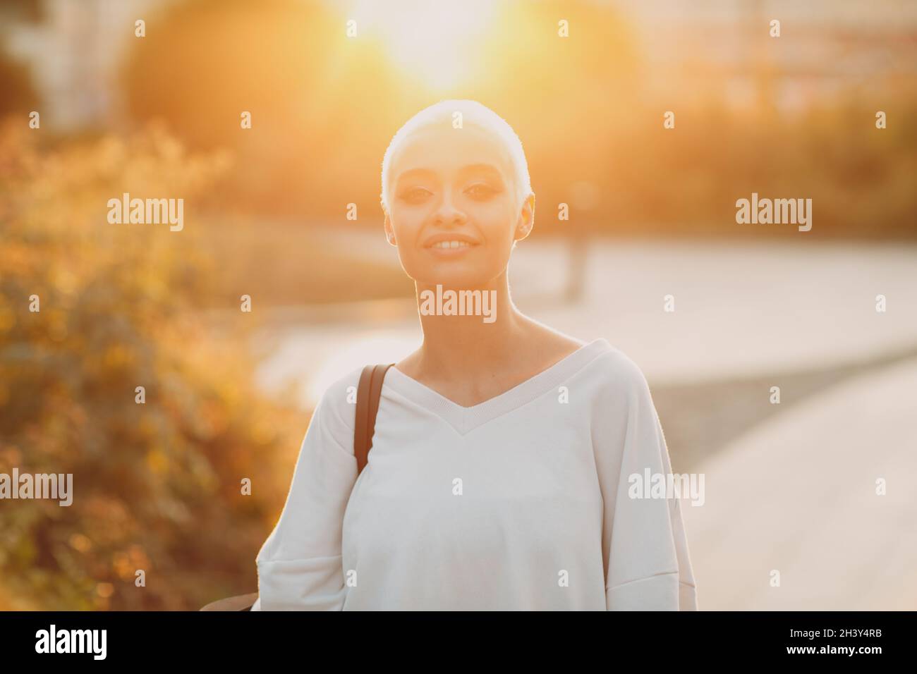 Millenial young woman blonde short hair outdoor smiling portrait. Stock Photo