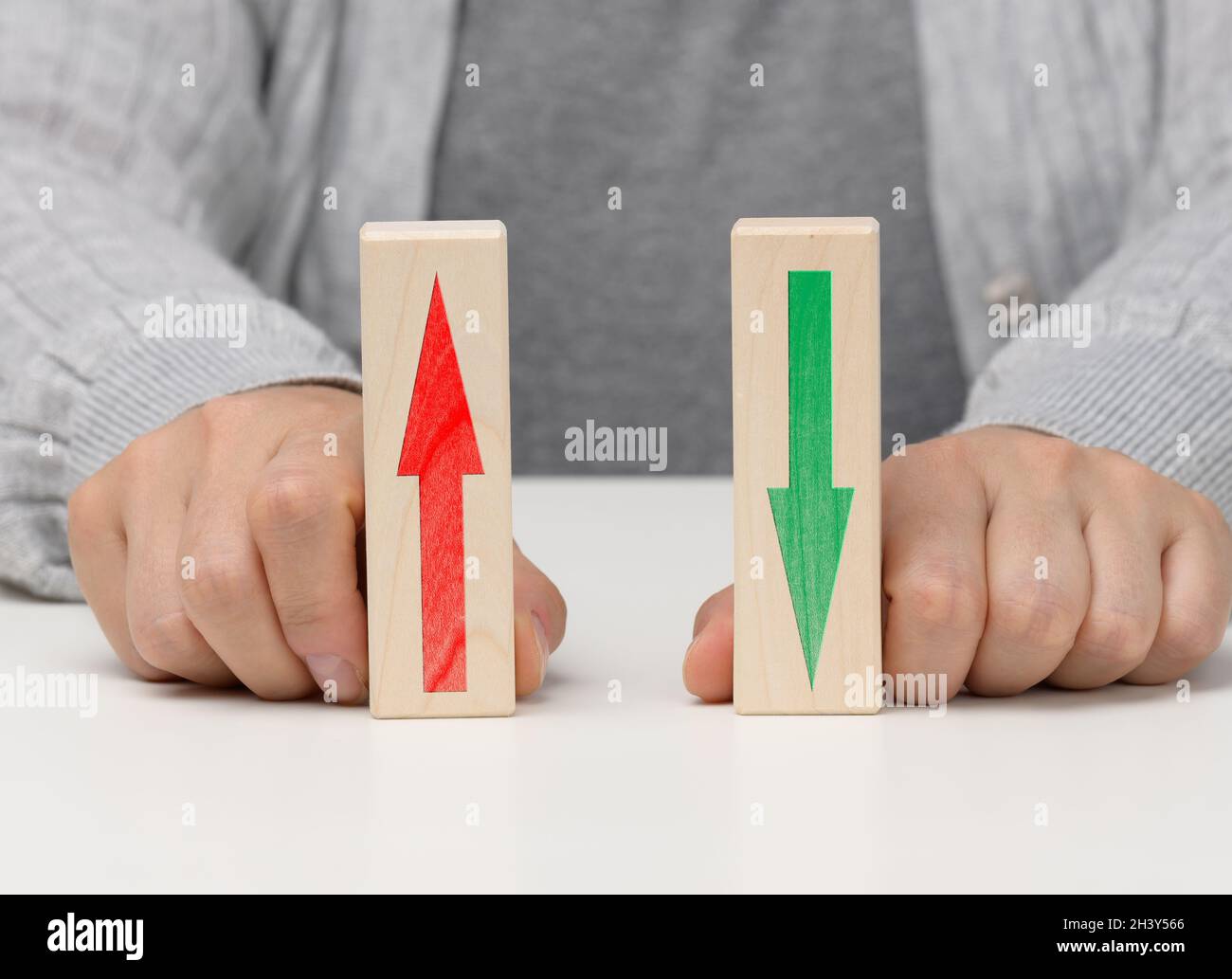 Female hand holds wooden blocks with up and down arrows. The concept of lowering and increasing indices, exchange rates. Dynamic Stock Photo