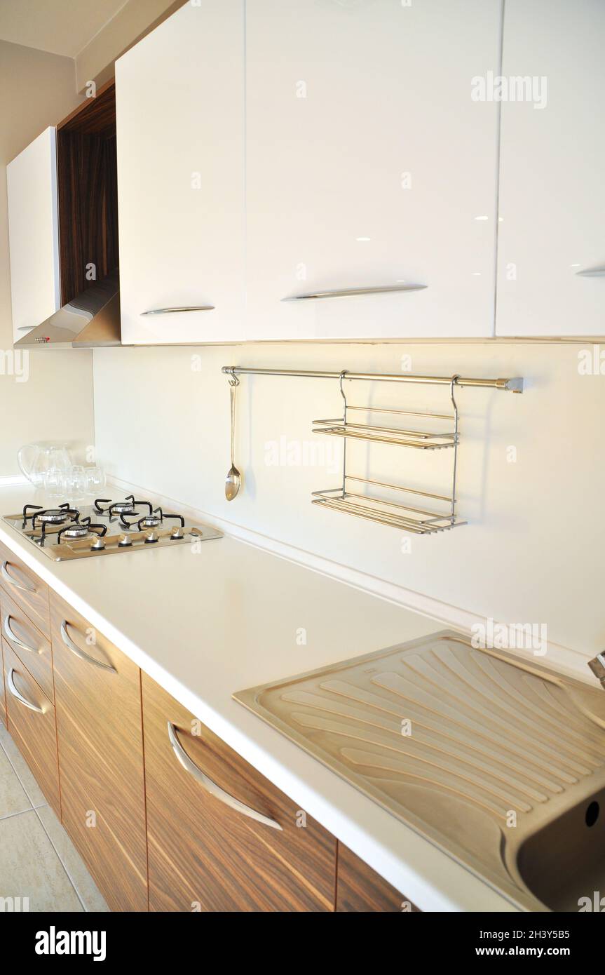 Interior of luxurious modern kitchen equipment, white and walnut