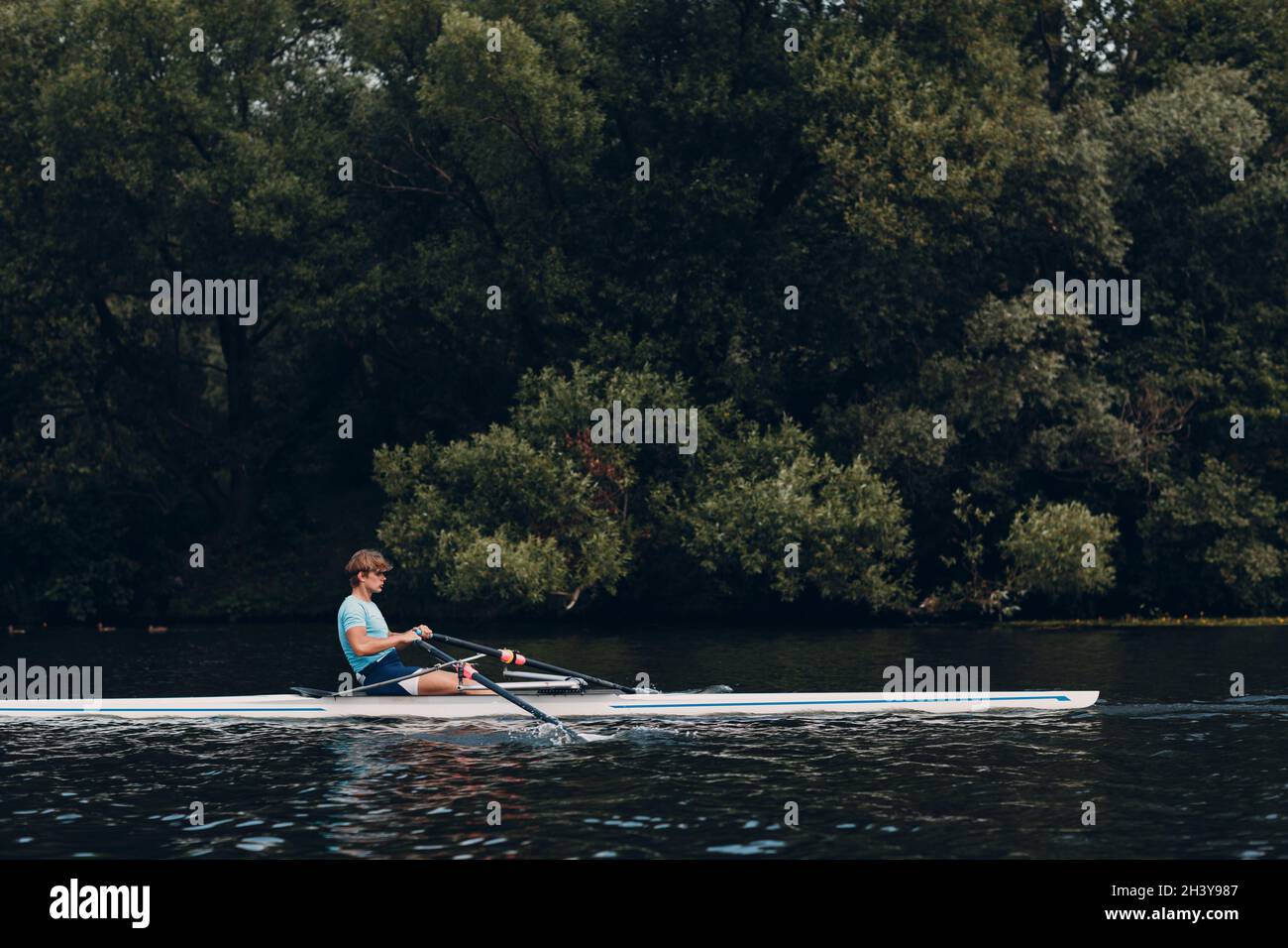 Sportsman single scull man rower rowing on boat Stock Photo