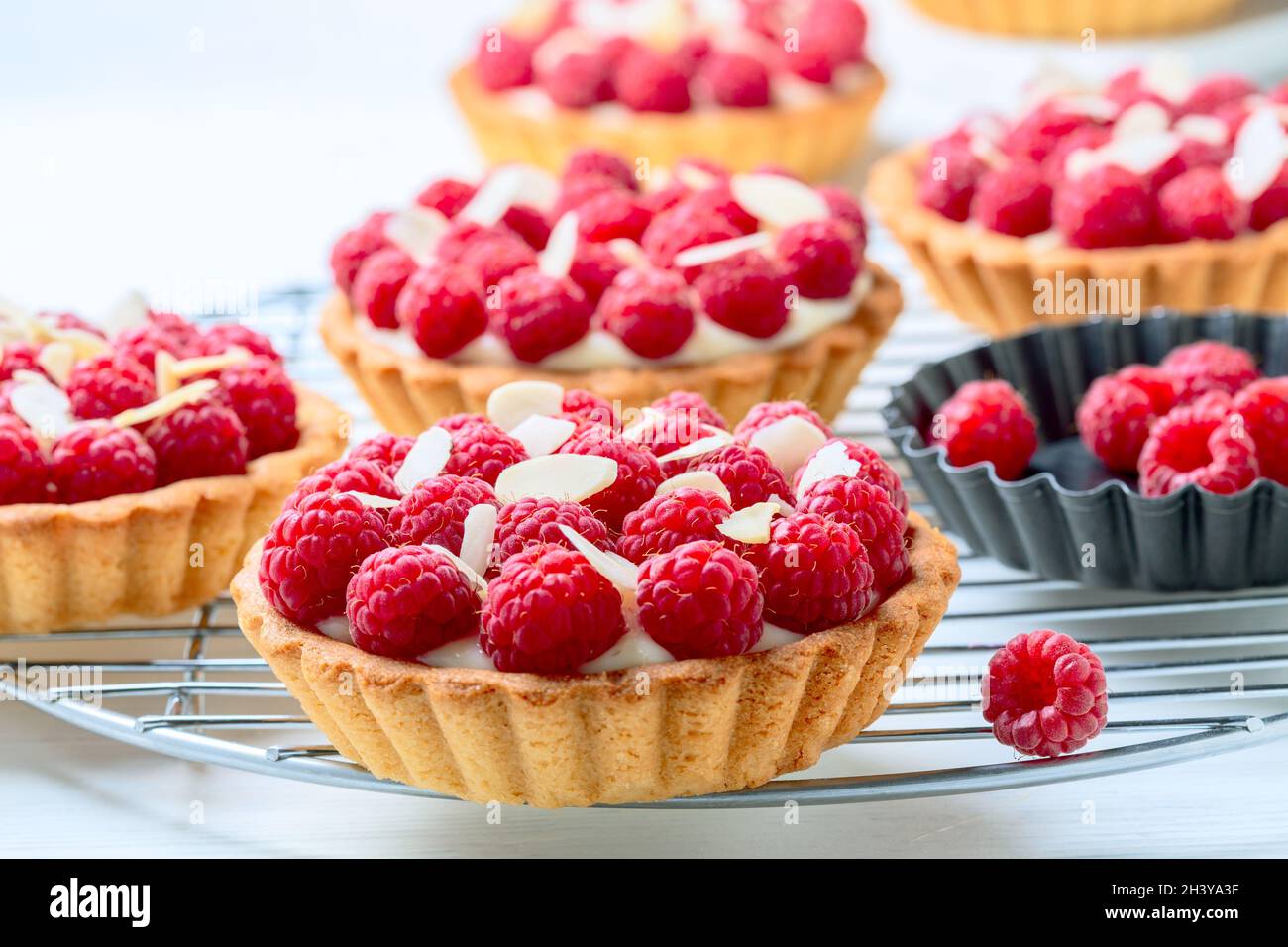 Tartlets with custard and raspberries. Stock Photo