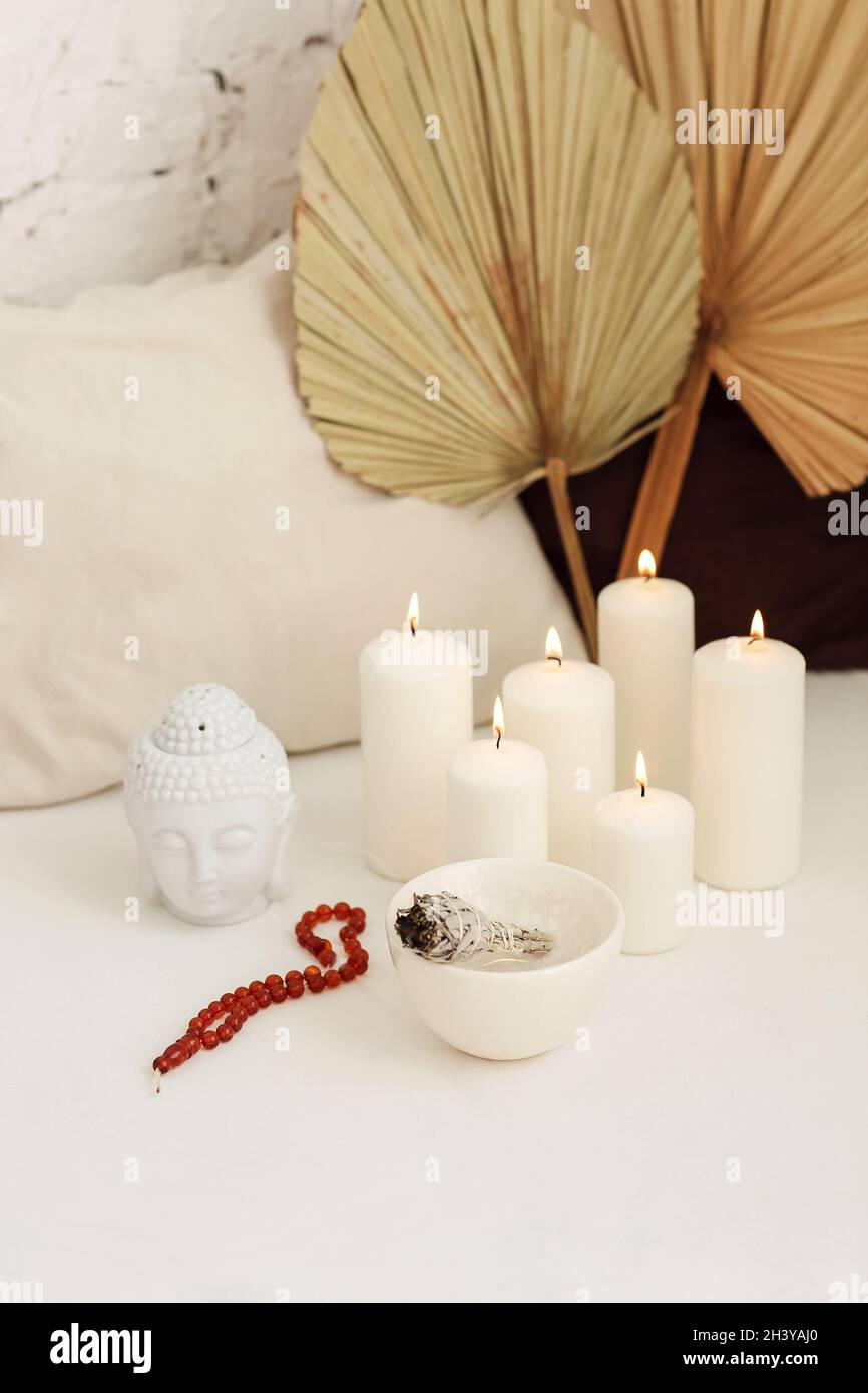 Meditation place with candles and smudge stick in yoga studio Stock
