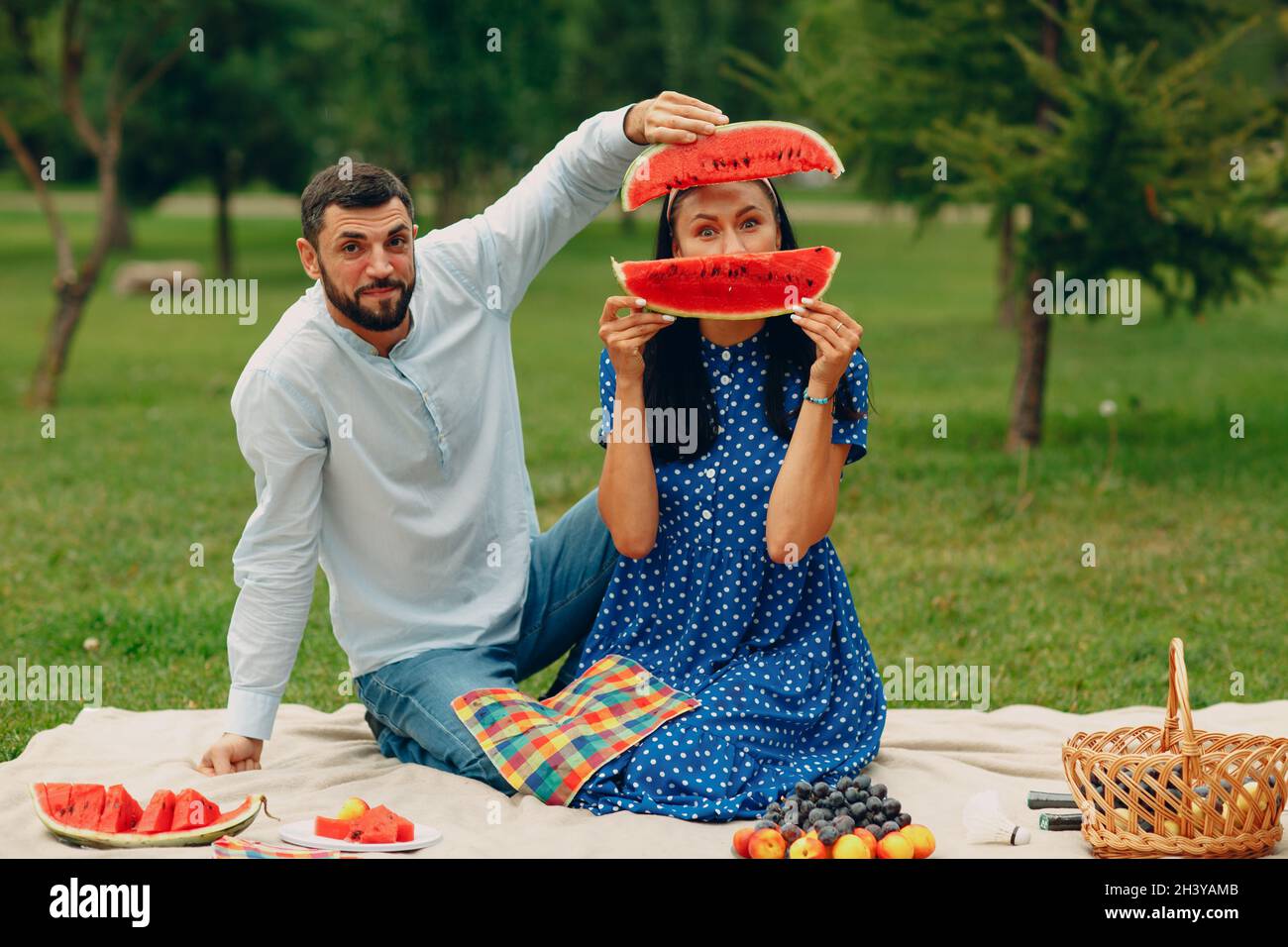 https://c8.alamy.com/comp/2H3YAMB/young-adult-woman-and-man-couple-picnic-at-green-grass-meadow-in-park-having-fun-with-watermelon-2H3YAMB.jpg