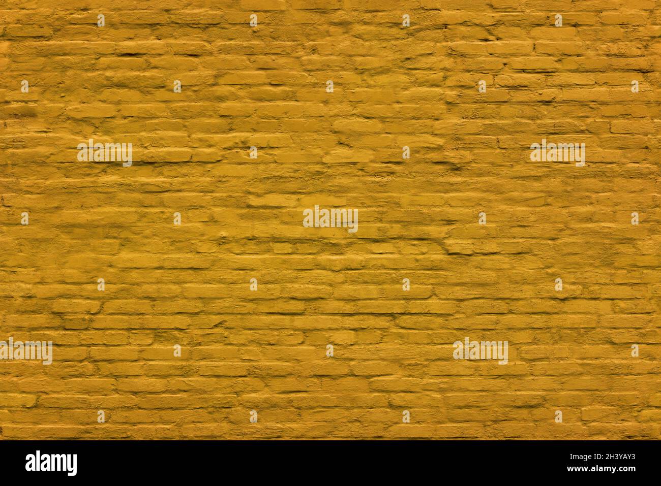 yellow seamless texture and full frame background of brick wall covered with matte plaster Stock Photo