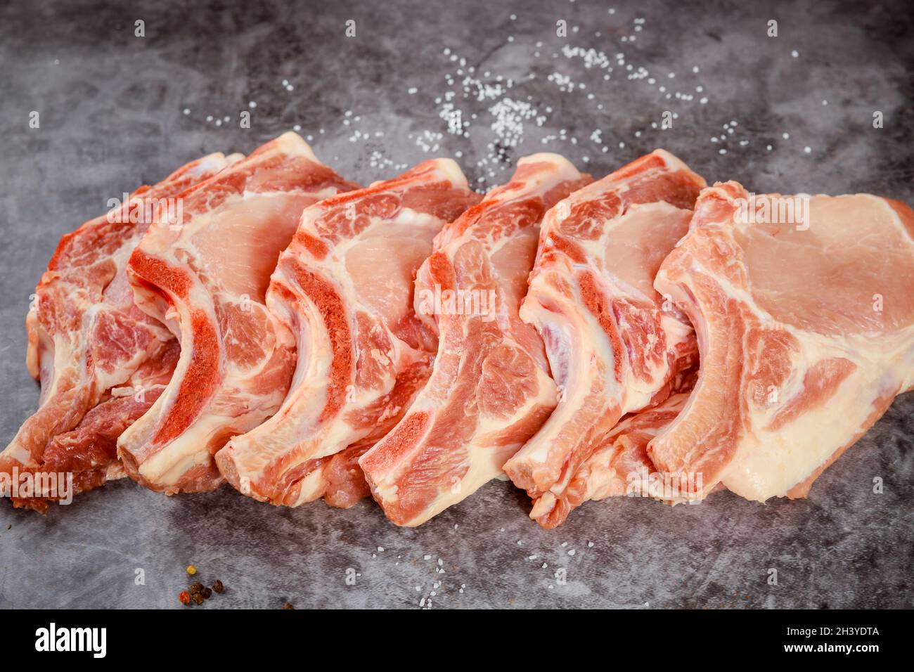 Raw pork chops bone in isolated on grey background. Stock Photo