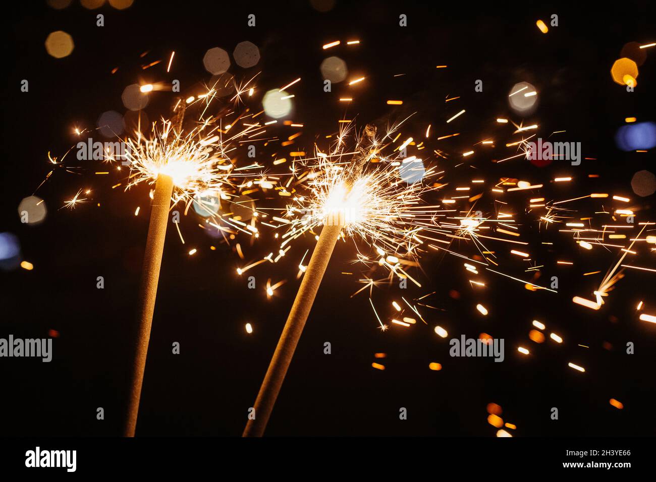 Bright glittering burning sparkler on dark background Stock Photo