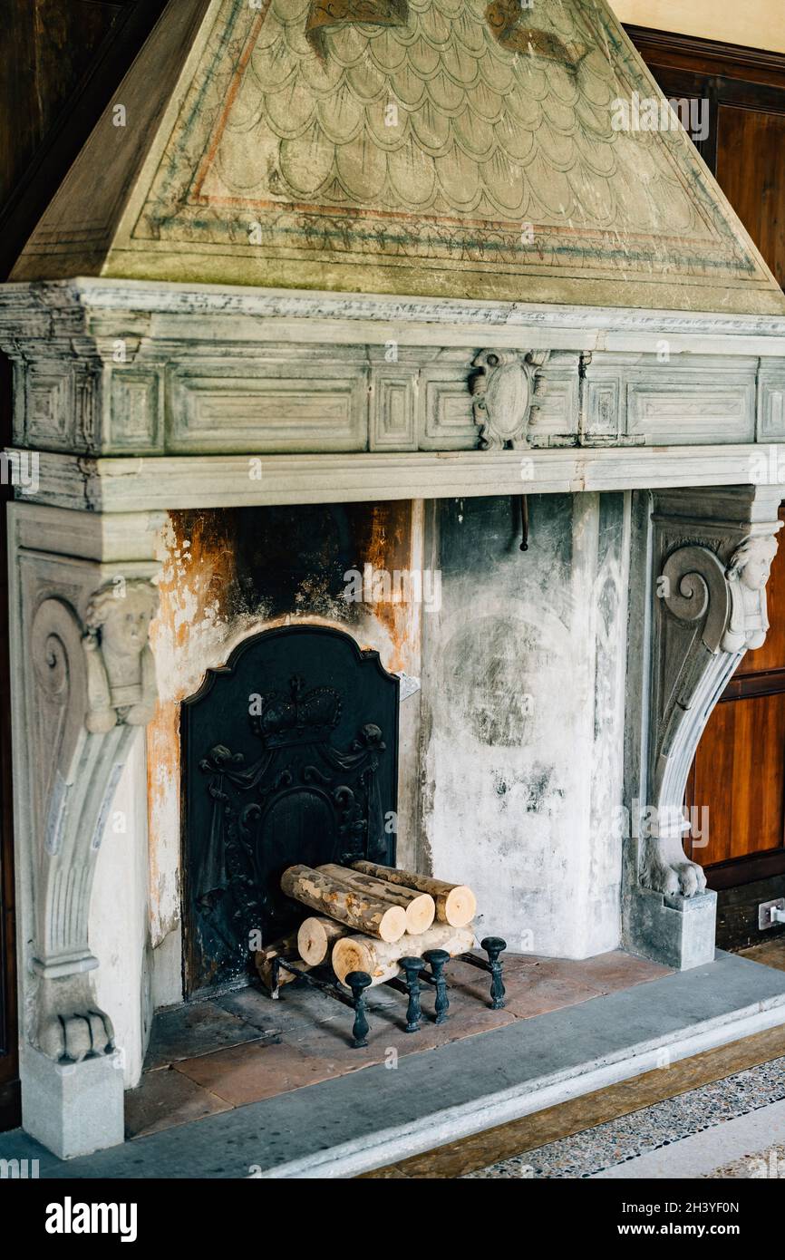 Old firebox in the house close-up. An ancient fireplace in the house with columns and bas-reliefs. Stock Photo