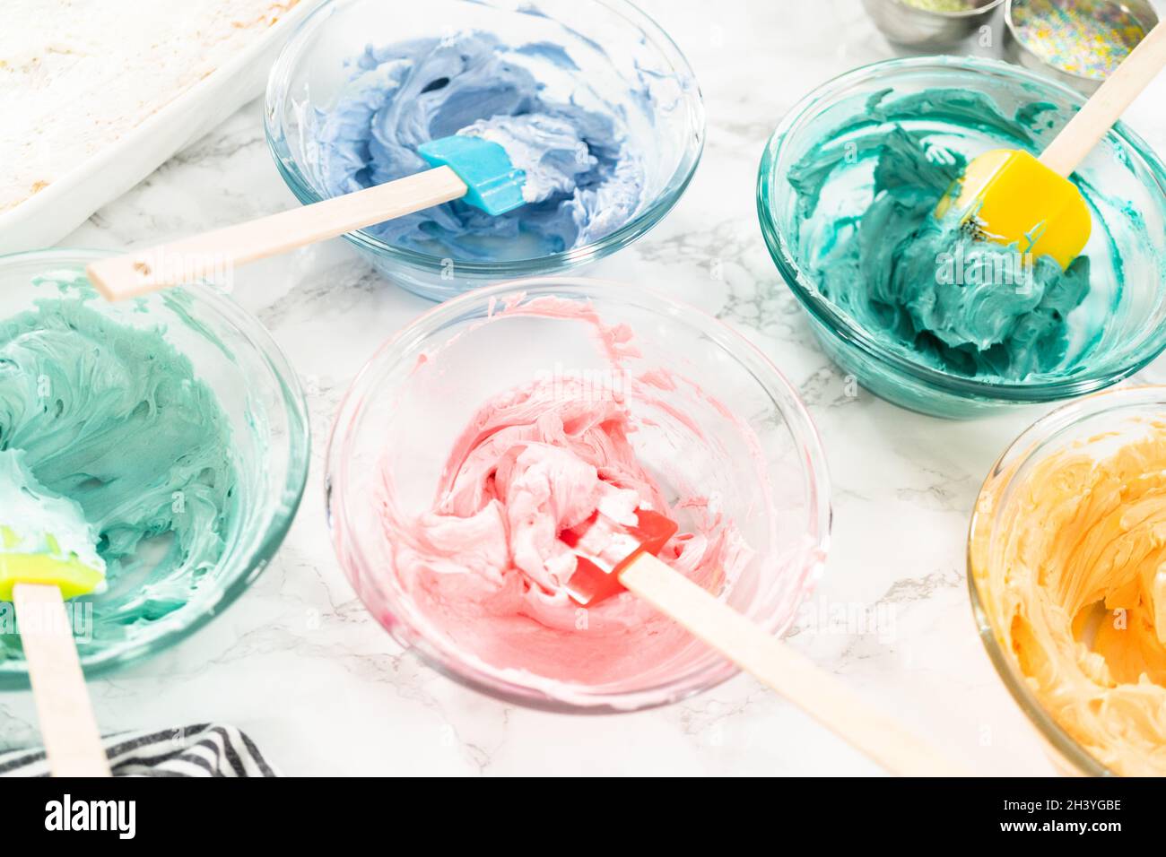 Mixing food coloring with Italian buttercream frosting Stock Photo Alamy