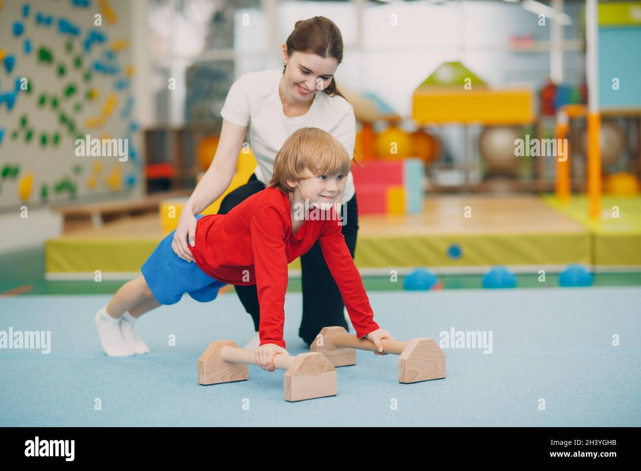 Kids doing exercises push up in gym at kindergarten or elementary school. Children sport and fitness concept. Stock Photo