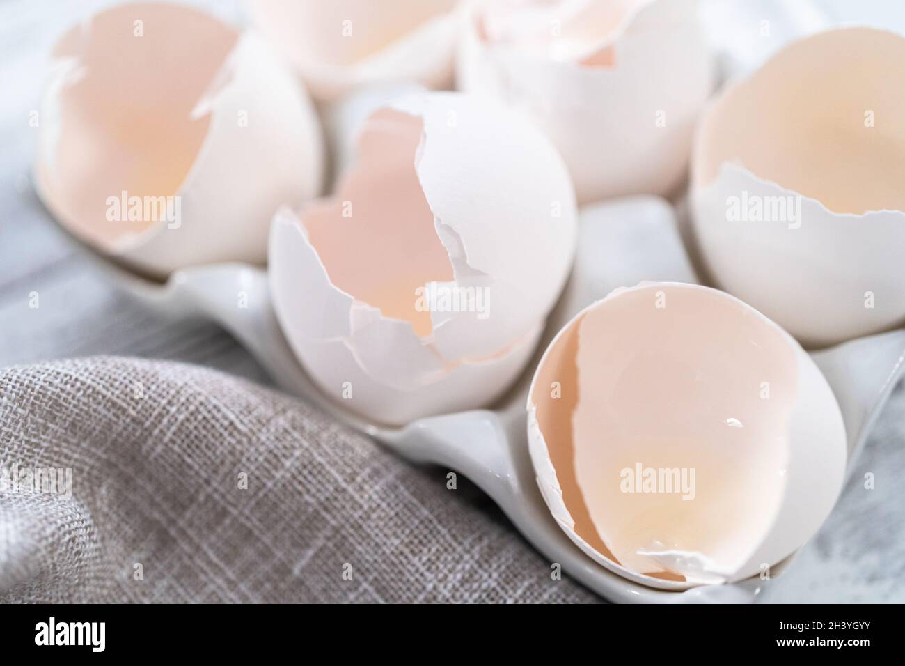 Empty egg shells from organic white eggs in ceramic egg crates. Stock Photo