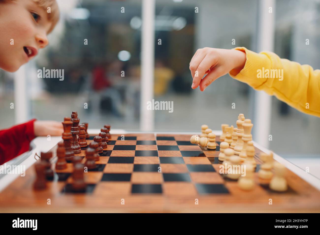 Little kids playing chess at kindergarten or elementary school. Children's chess play. Stock Photo