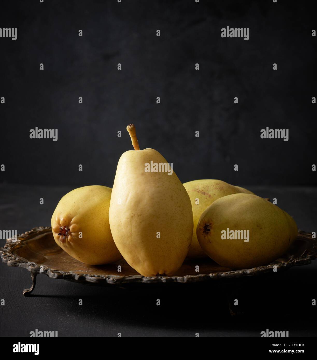 Ripe green pears on a metal plate, black background Stock Photo