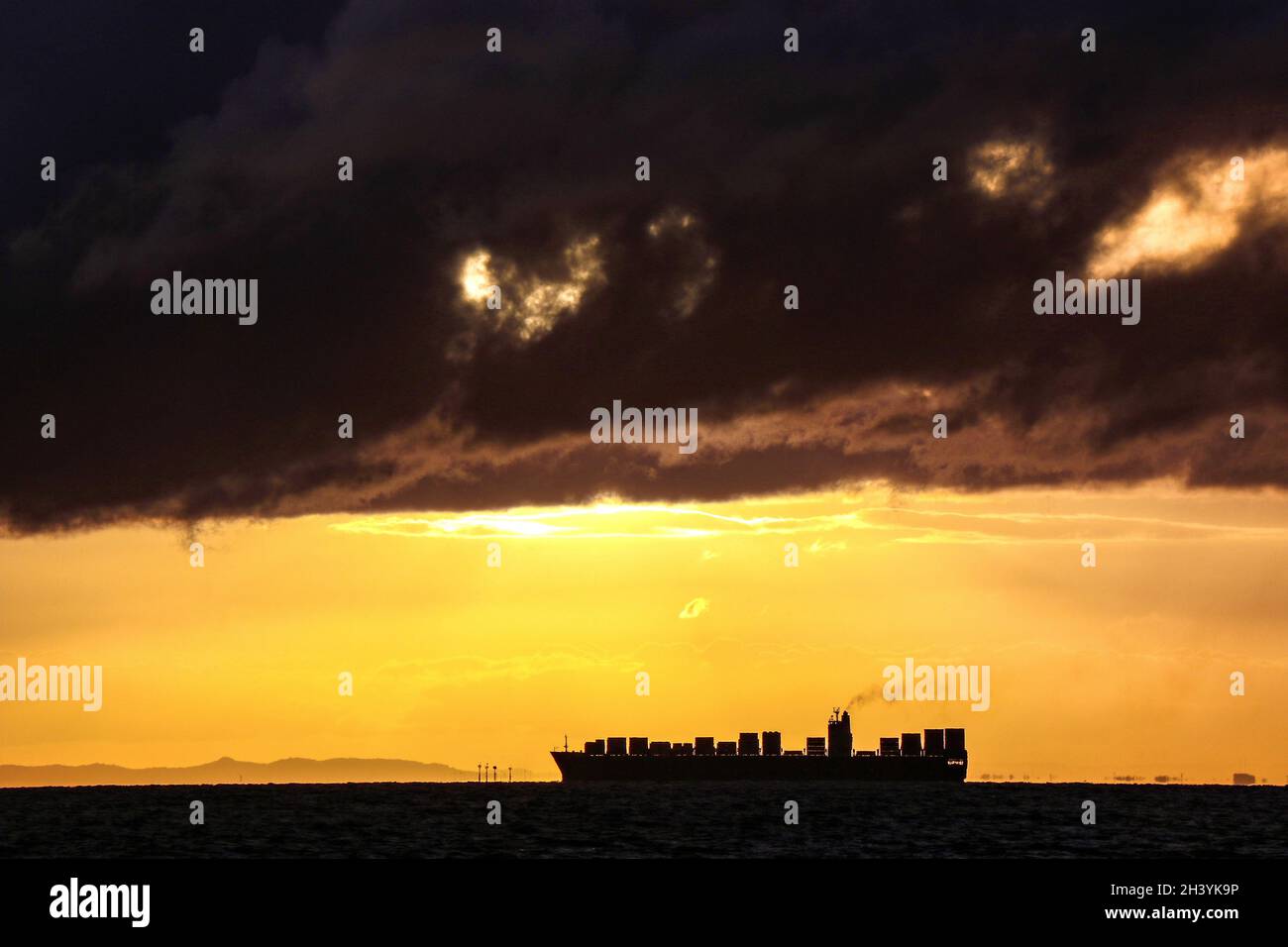 A symbol of trade, commerce, and the economy, a container ship on the horizon in Port Phillip Bay Melbourne, Australia . Stock Photo