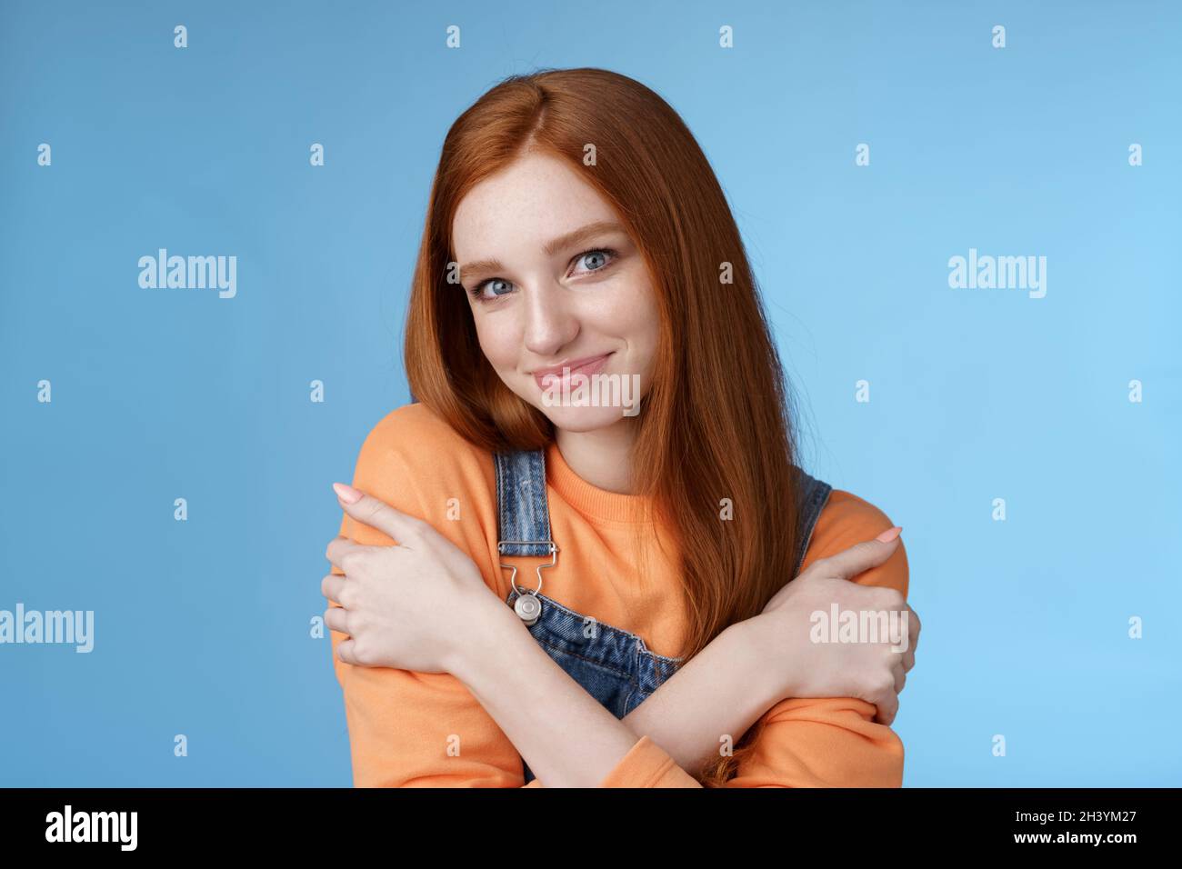 Romantic sensitive flirty young redhead girlfriend feel warmth embraces hugging herself hands crossed body tilting head smiling Stock Photo