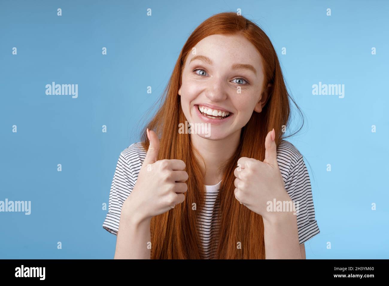 Nice idea keep up. Supportive tender cute european ginger girl blue eyes cheering friend boost mood show thumbs up smiling appro Stock Photo