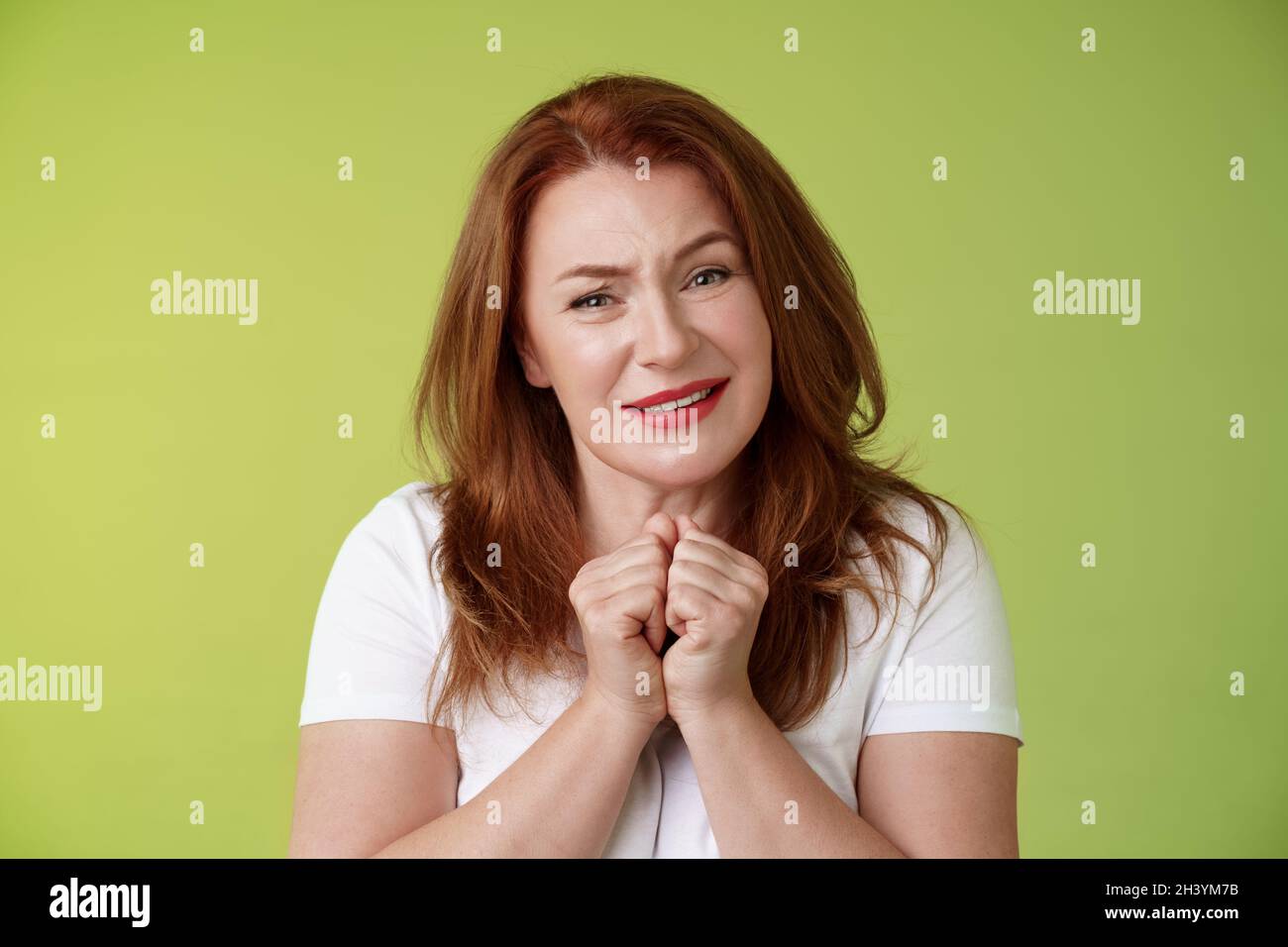 Silly touched tender redhead charmed middle-aged woman sighing gladly gaze admiration delighted press hands together heartwarmed Stock Photo