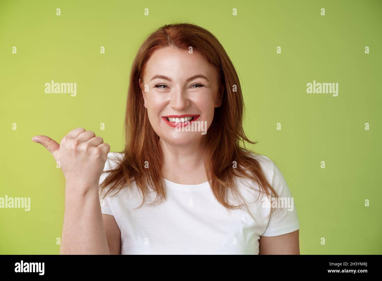 Come visit our store. Cheerful pleasant friendly charming redhead middle-aged woman entrepreneur inviting check-out promo smilin Stock Photo