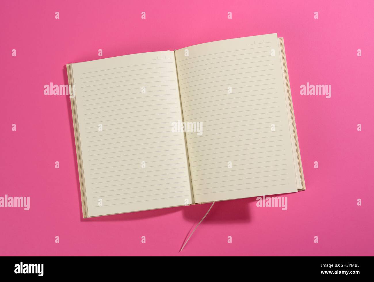 Open notebook with blank white sheets on pink background Stock Photo