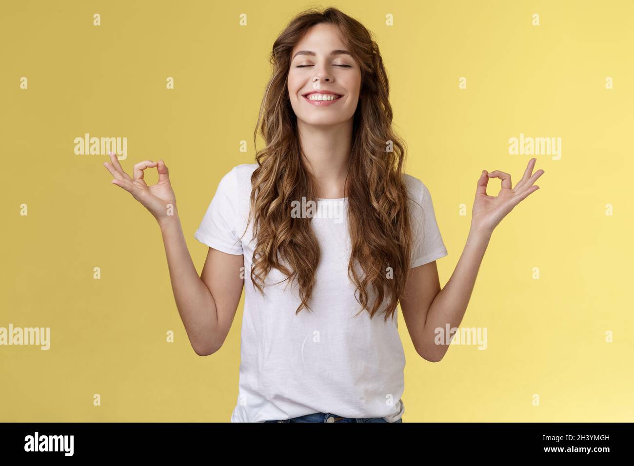 Patience, happiness, wellbeing. Cheerful relieved attractive peaceful relaxed young happy girl breathe inhale air smiling broadl Stock Photo