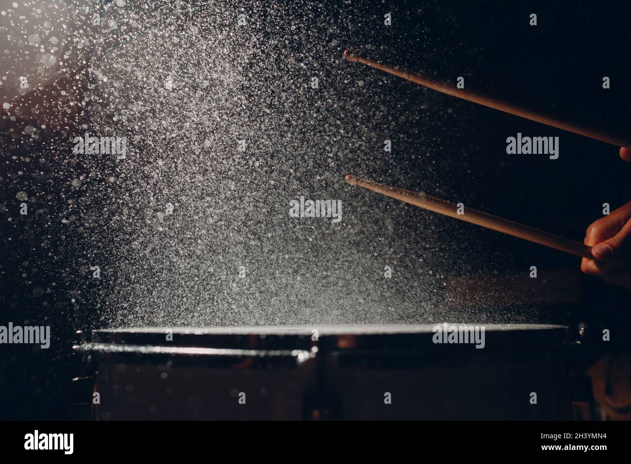 Drum sticks drumming beat rhythm on drum surface with splash water