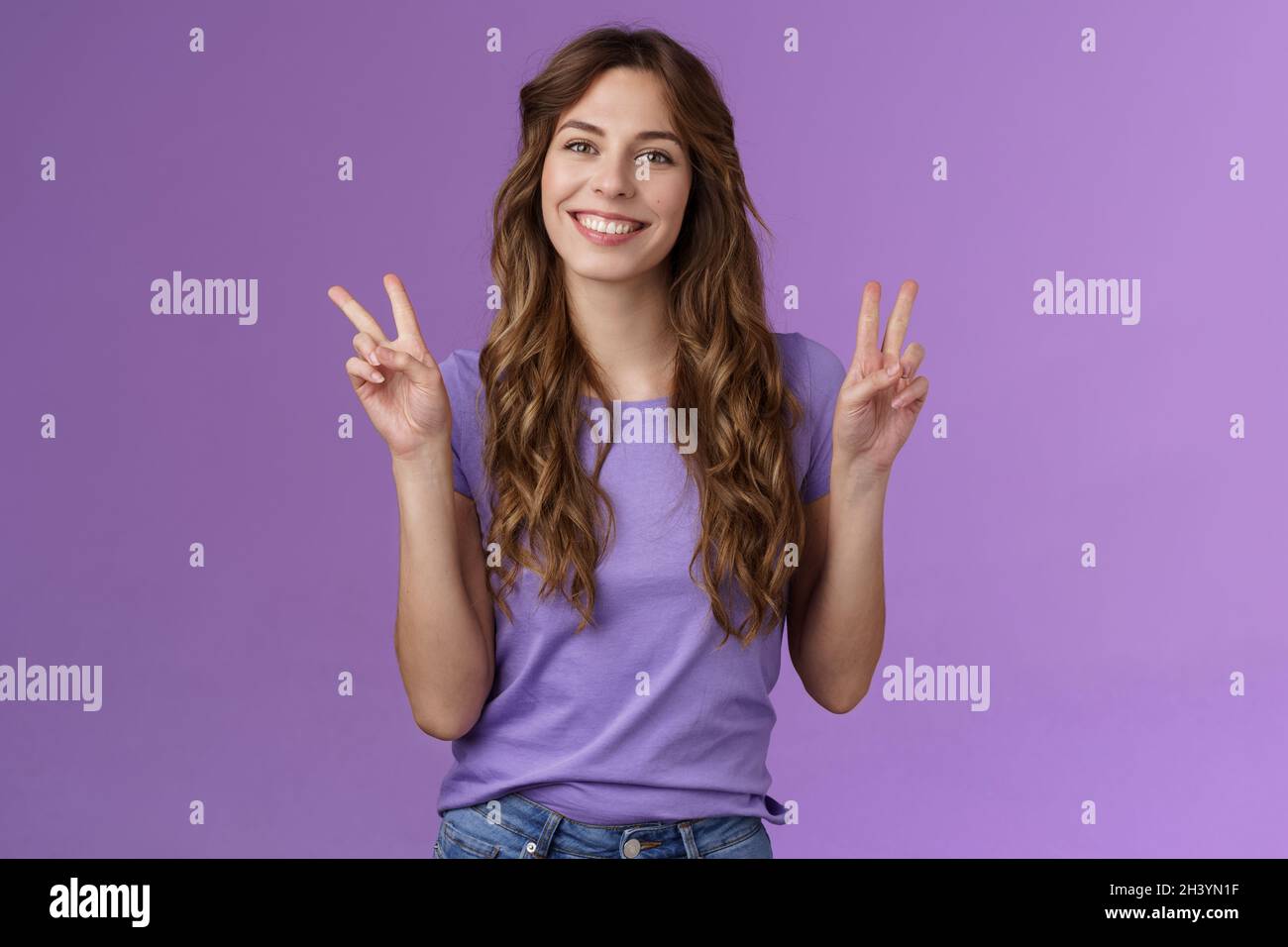 Peace friends. Relaxed friendly cute self-assured girl long curly hairstyle show victory sign smiling broadly cheering express p Stock Photo