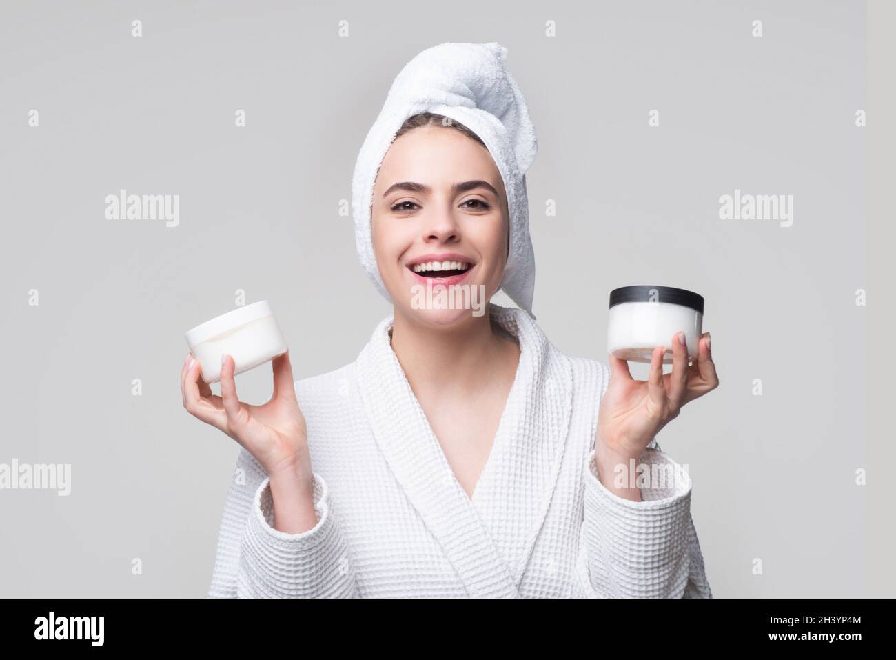 Portrait of beauty girl putting cosmetic cream on face. Female skin ...