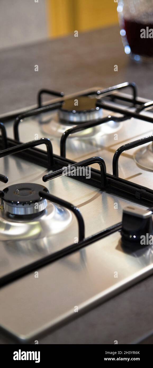 Stainless grey metal kitchen gas stove installed on a the kitchen with a  dark grey table top Stock Photo - Alamy