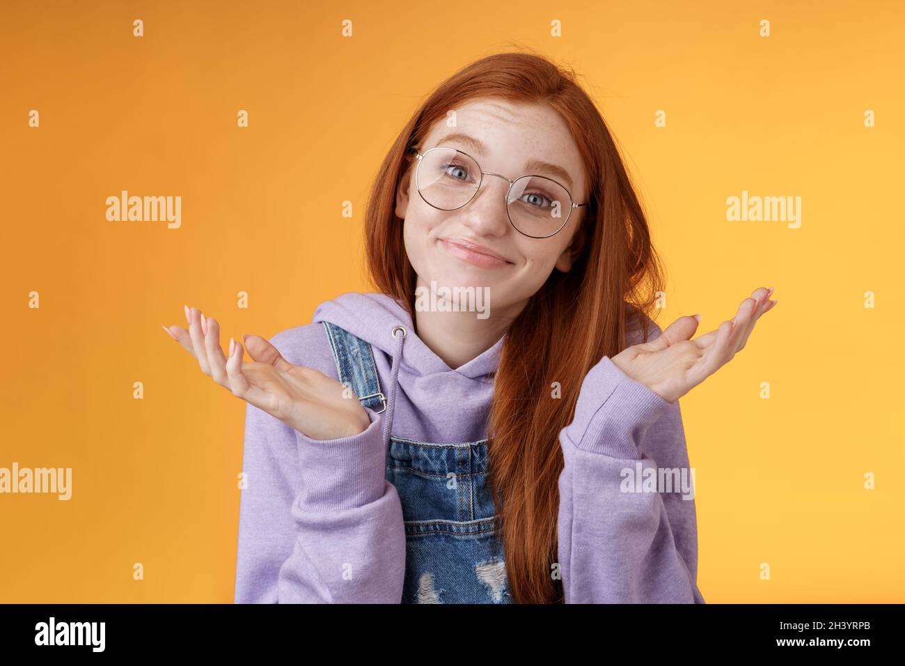 Nothing much. Attractive silly unsure carefree redhead unbothered cute female wearing geek glasses smirking uncertain shrugging Stock Photo