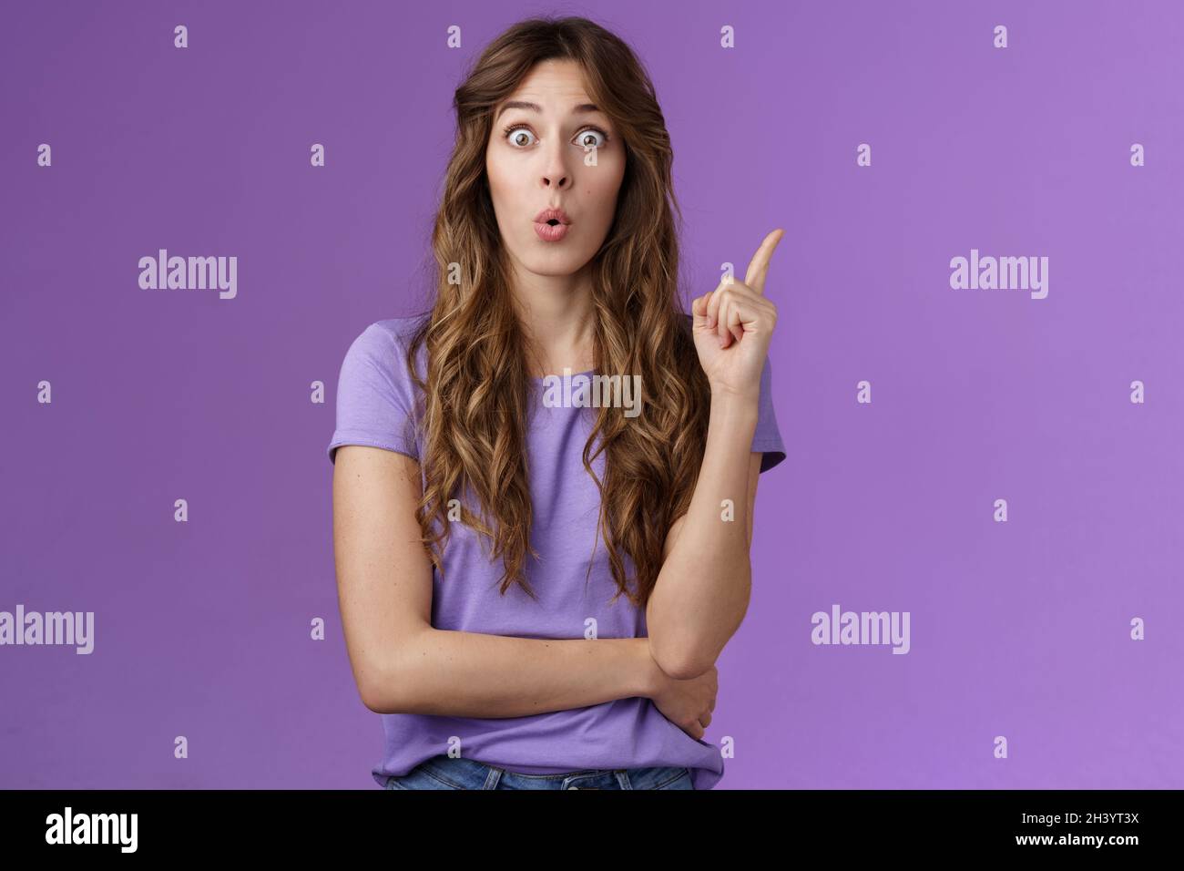 Got it eureka. Excited enthusiastic creative cute european girl raise index finger folding lips wow great found solution suggest Stock Photo