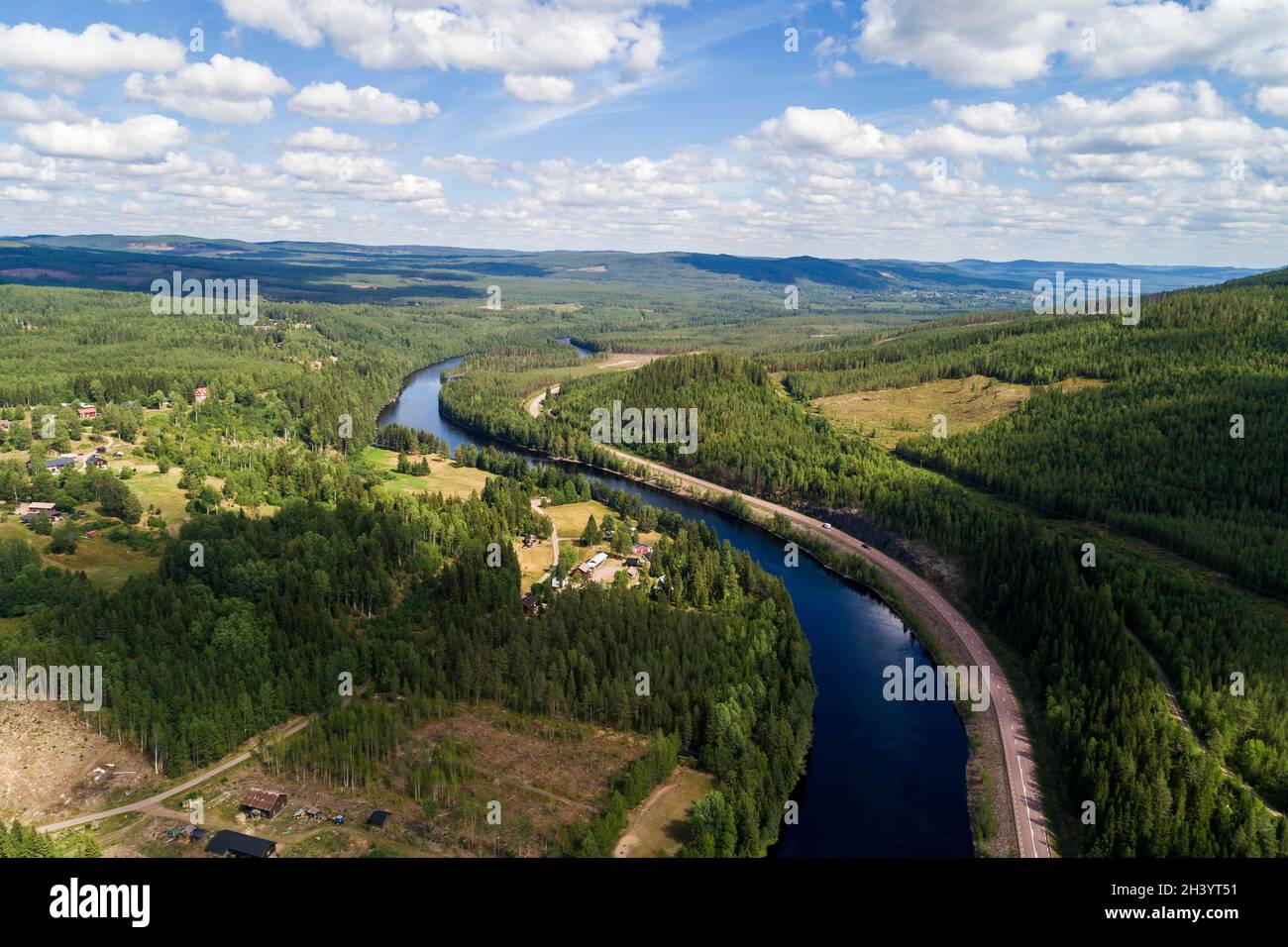 River and road running through forest and mountainous landscape ,aerial view  Stock Photo