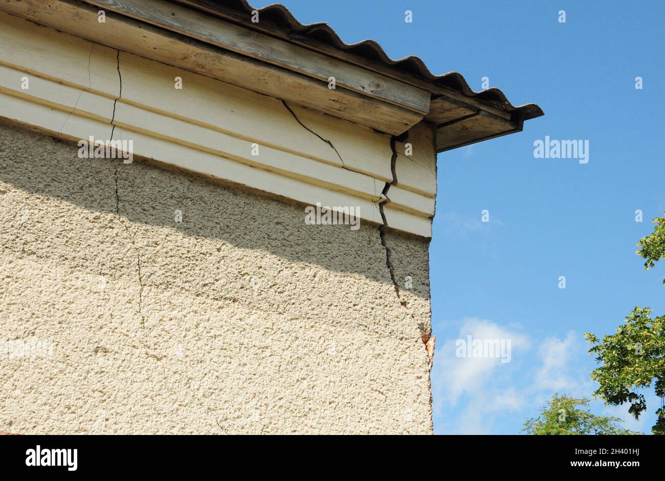 House wall stucco cracks on the roof corner. Stock Photo