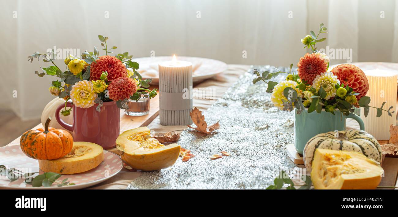 Festive table setting with pumpkins and chrysanthemum flowers. Stock Photo