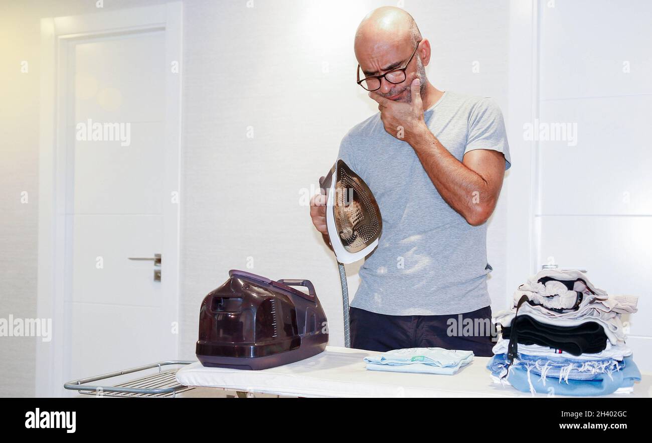 A Hispanic male householder from Spain wondering how to do ironing in a