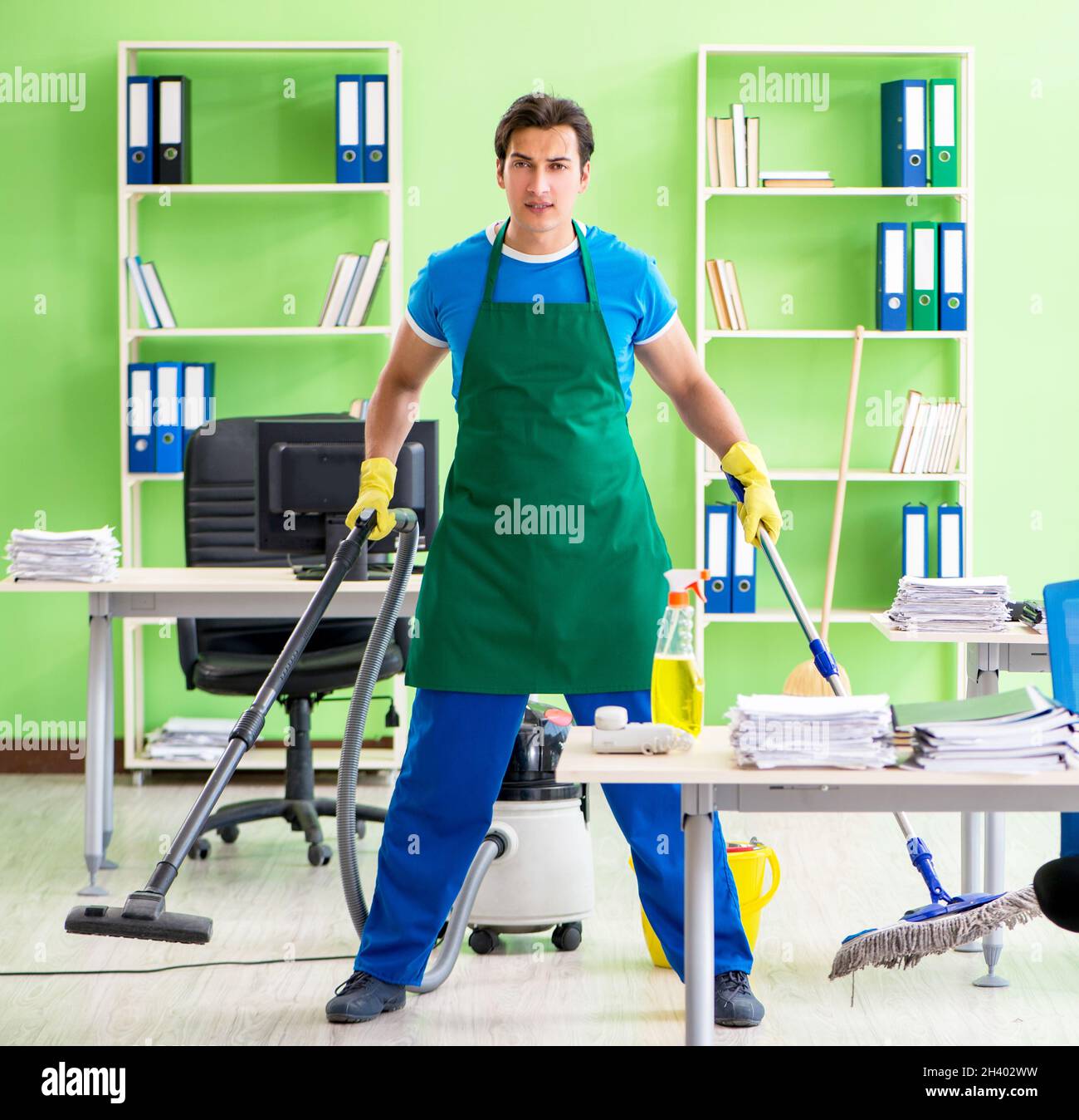 Handsome man cleaning office with vacuum cleaner Stock Photo Alamy