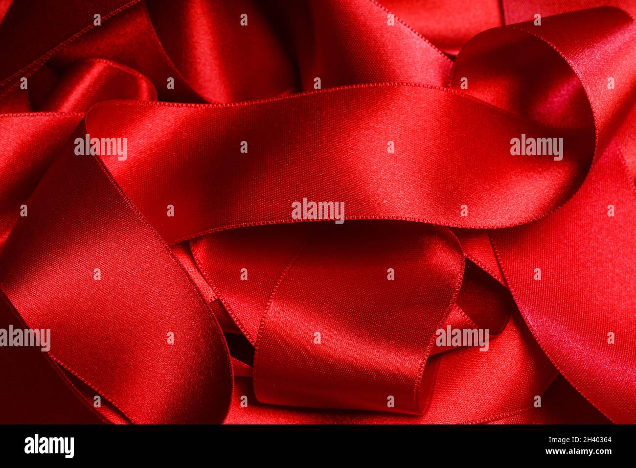 Masses heap of red satin ribbon background Holiday Christmas gift package concept Stock Photo