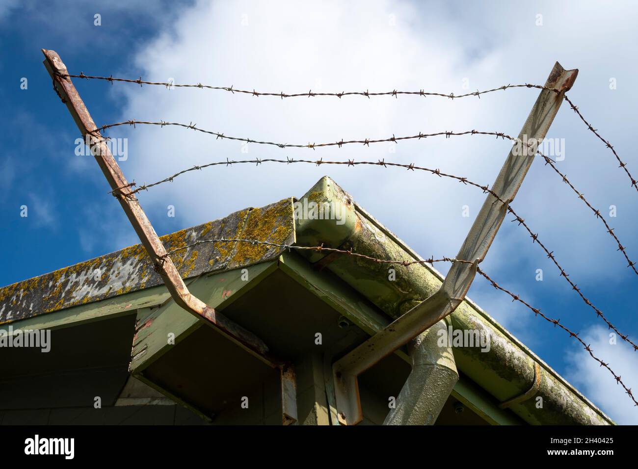 Barbed wire around roof of old building, Titahi Bay, Porirua