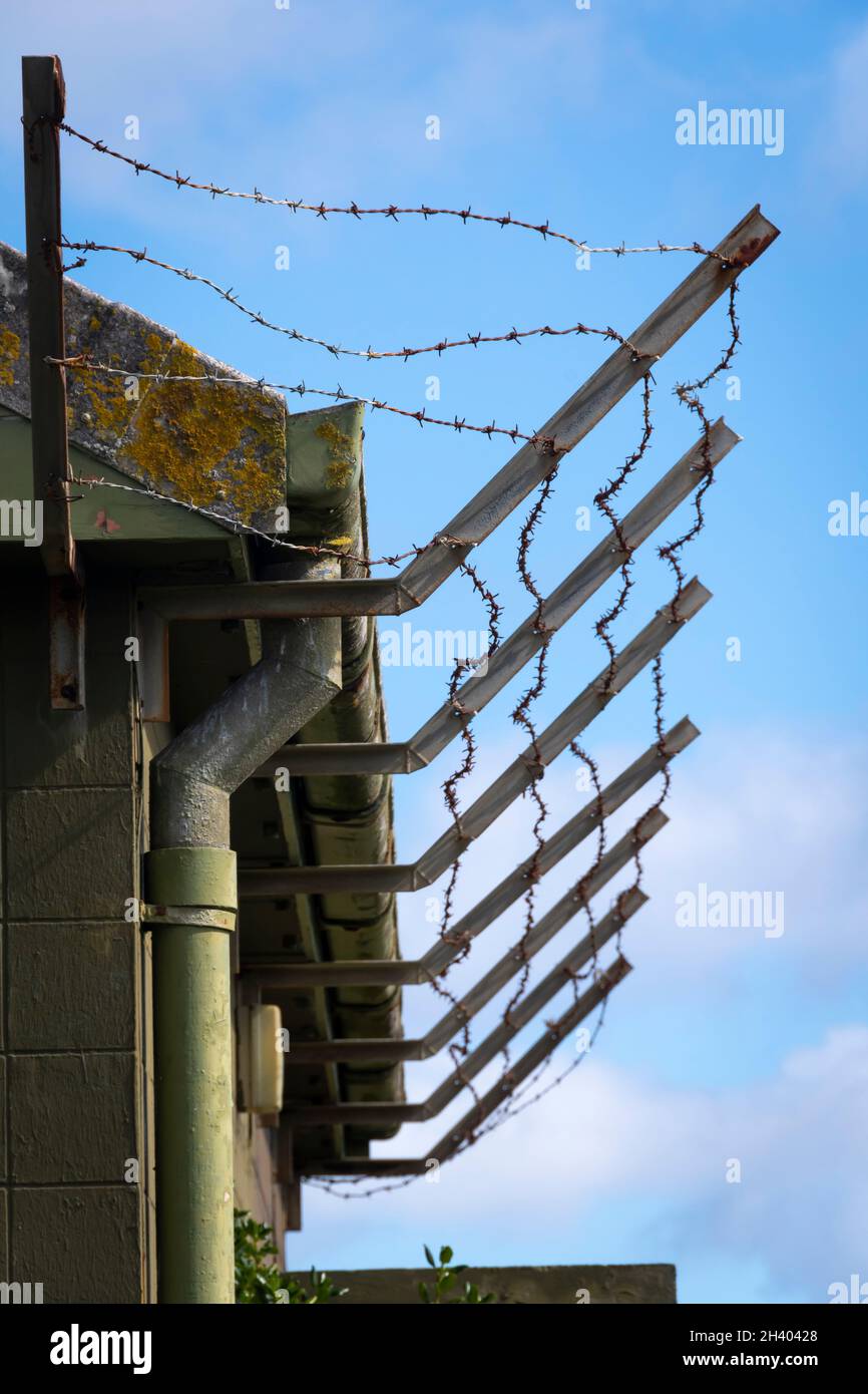 Barbed wire around roof of old building, Titahi Bay, Porirua