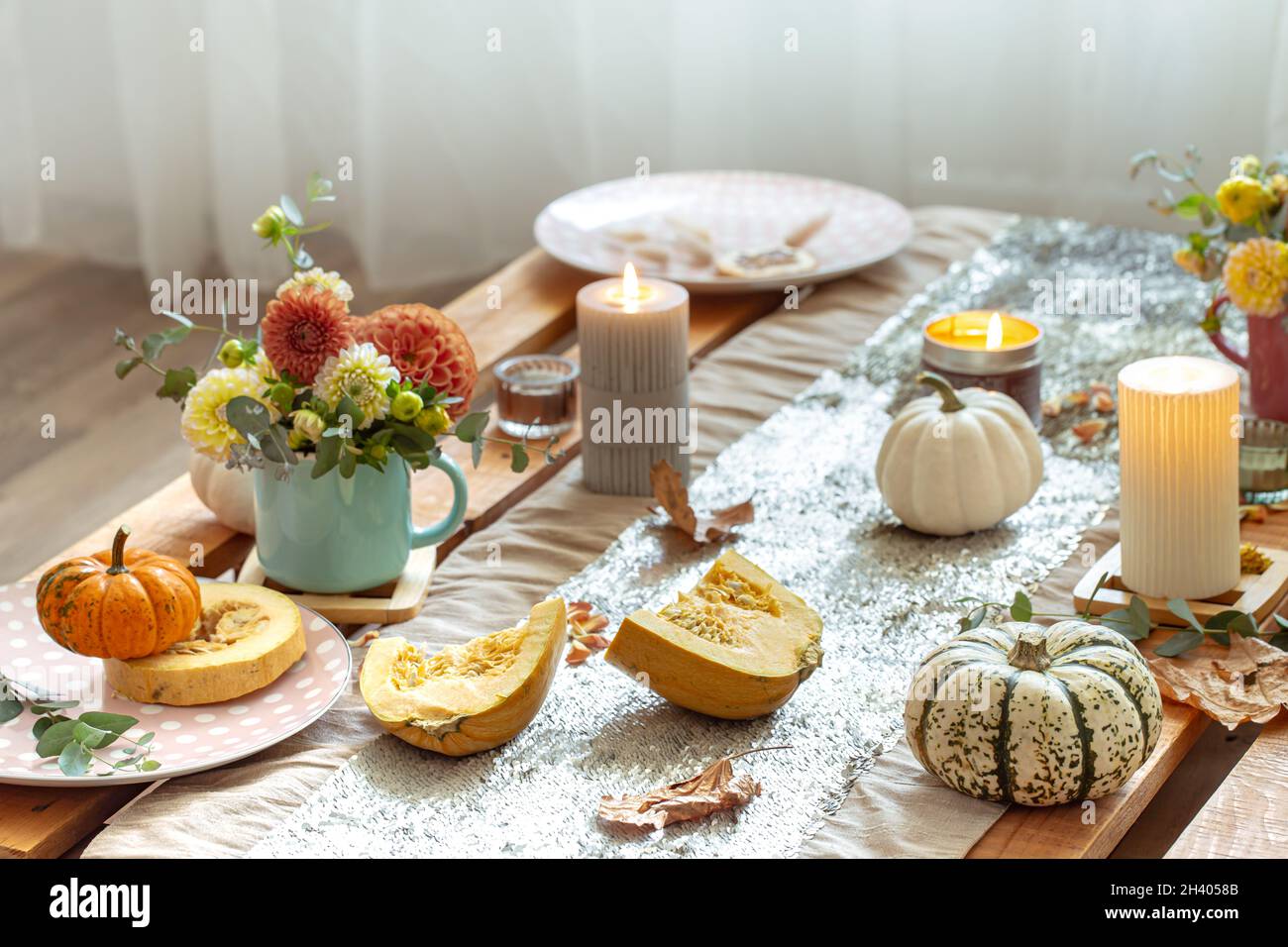 Festive table setting with pumpkins and chrysanthemum flowers. Stock Photo