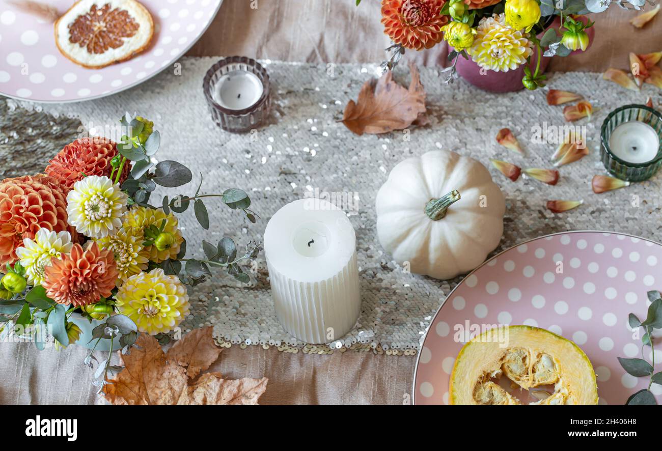 Festive table setting with pumpkins, candles and chrysanthemum flowers ...