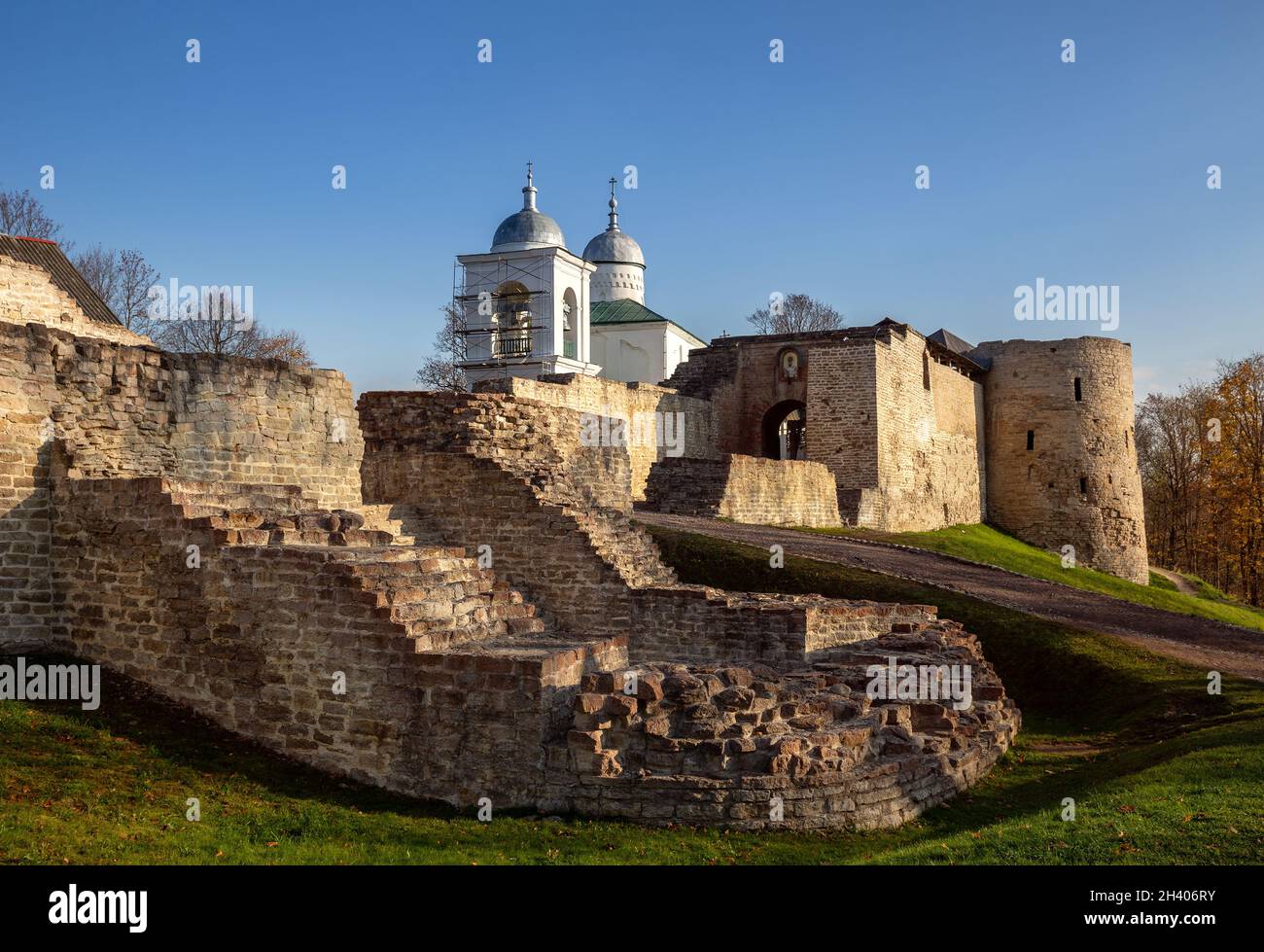 Izborsk, Russia - October 2021: Fortress walls and towers of the Izborsk fortress and the Church of St. Nicholas the Wonderworker, Pskov region Stock Photo