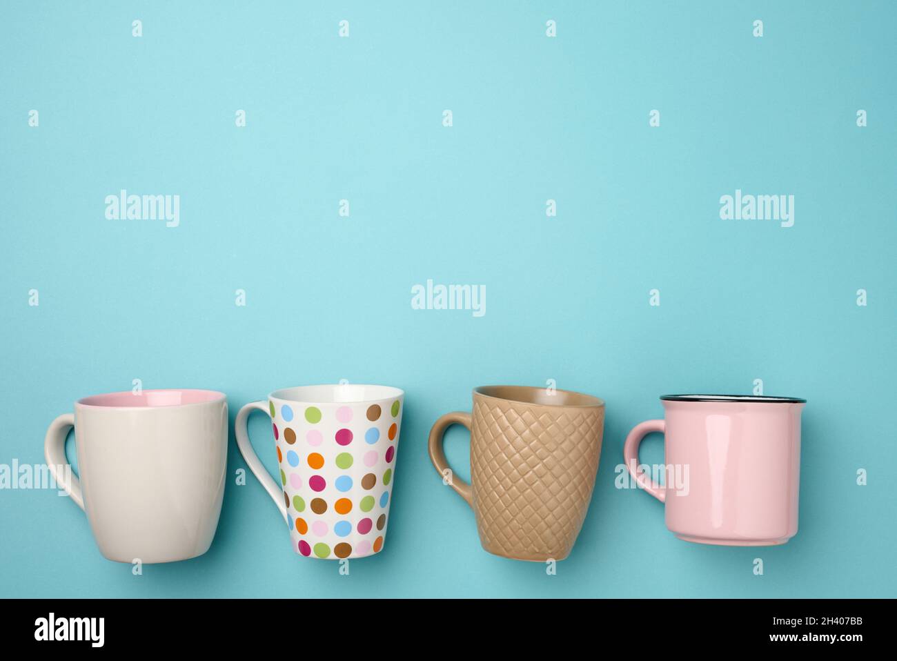 Stack of empty ceramic cup on a blue background, flat lay Stock Photo