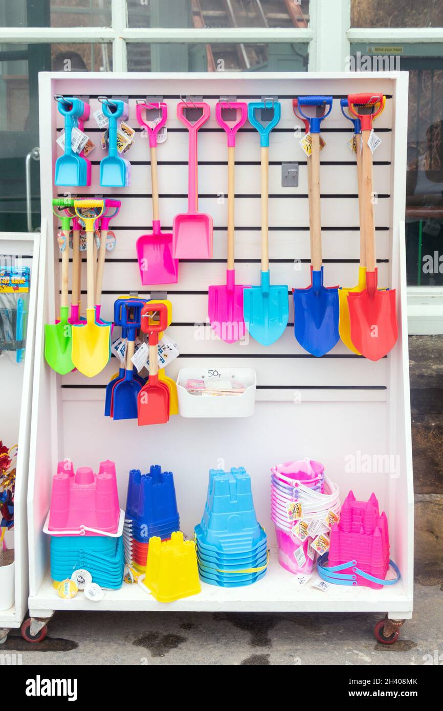 display of brightly coloured plastic buckets and spades and beach toys