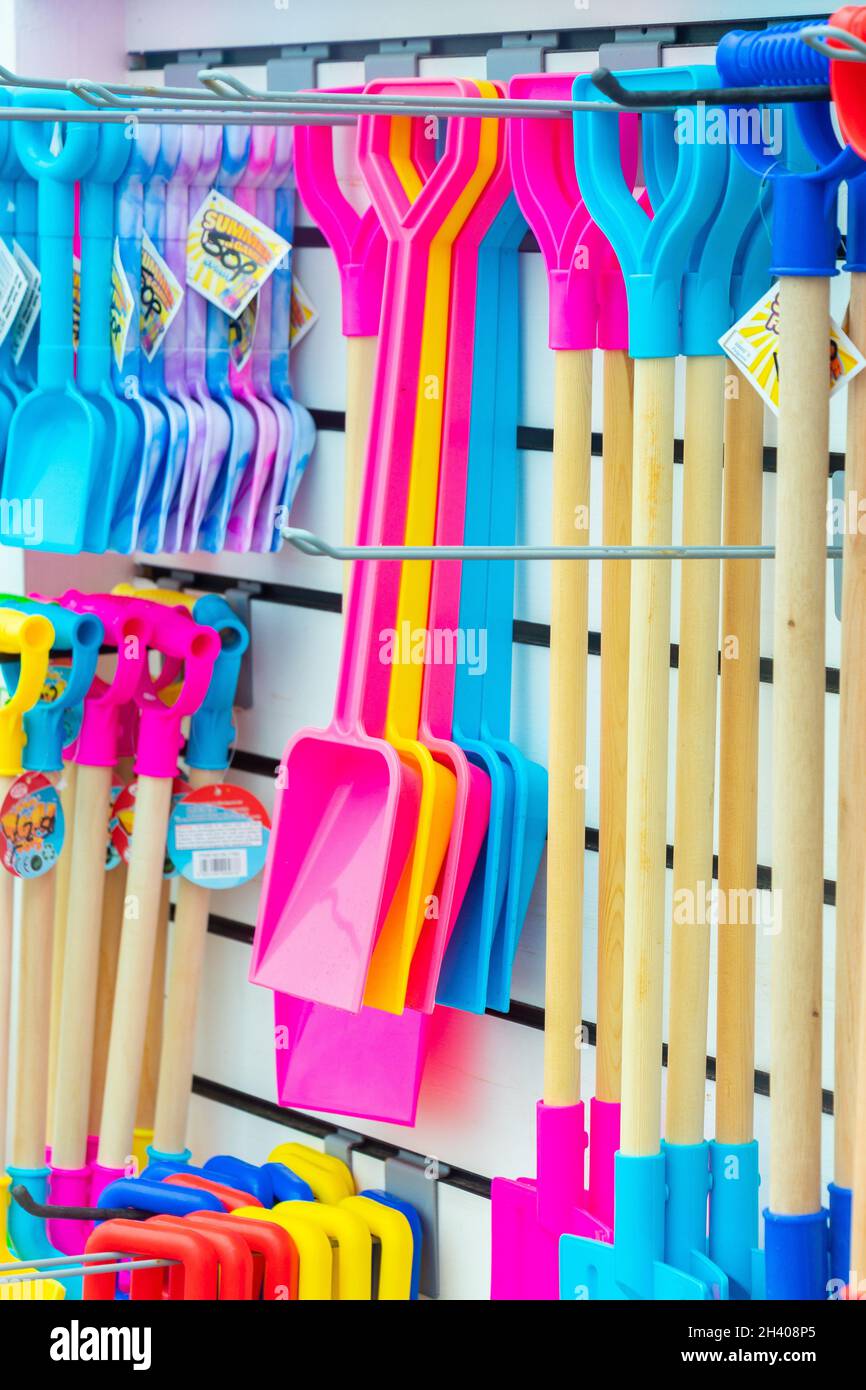 display of brightly coloured plastic buckets and spades and beach toys
