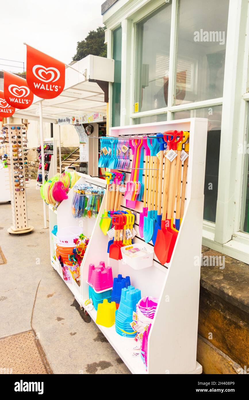 display of brightly coloured plastic buckets and spades and beach toys