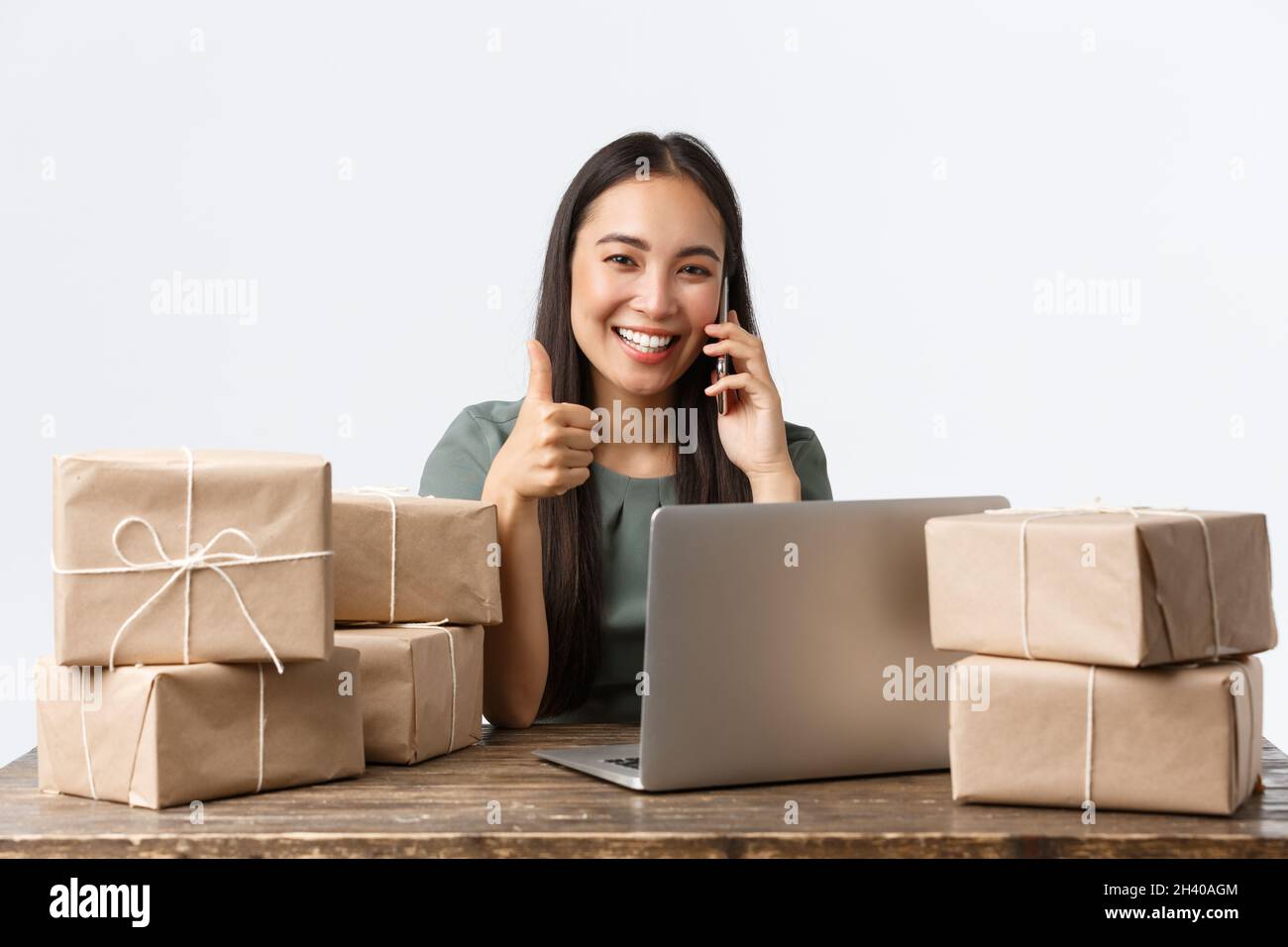 Small business owners, startup and e-commerce concept. Smiling asian woman manage online store, businesswoman answer phone call, Stock Photo