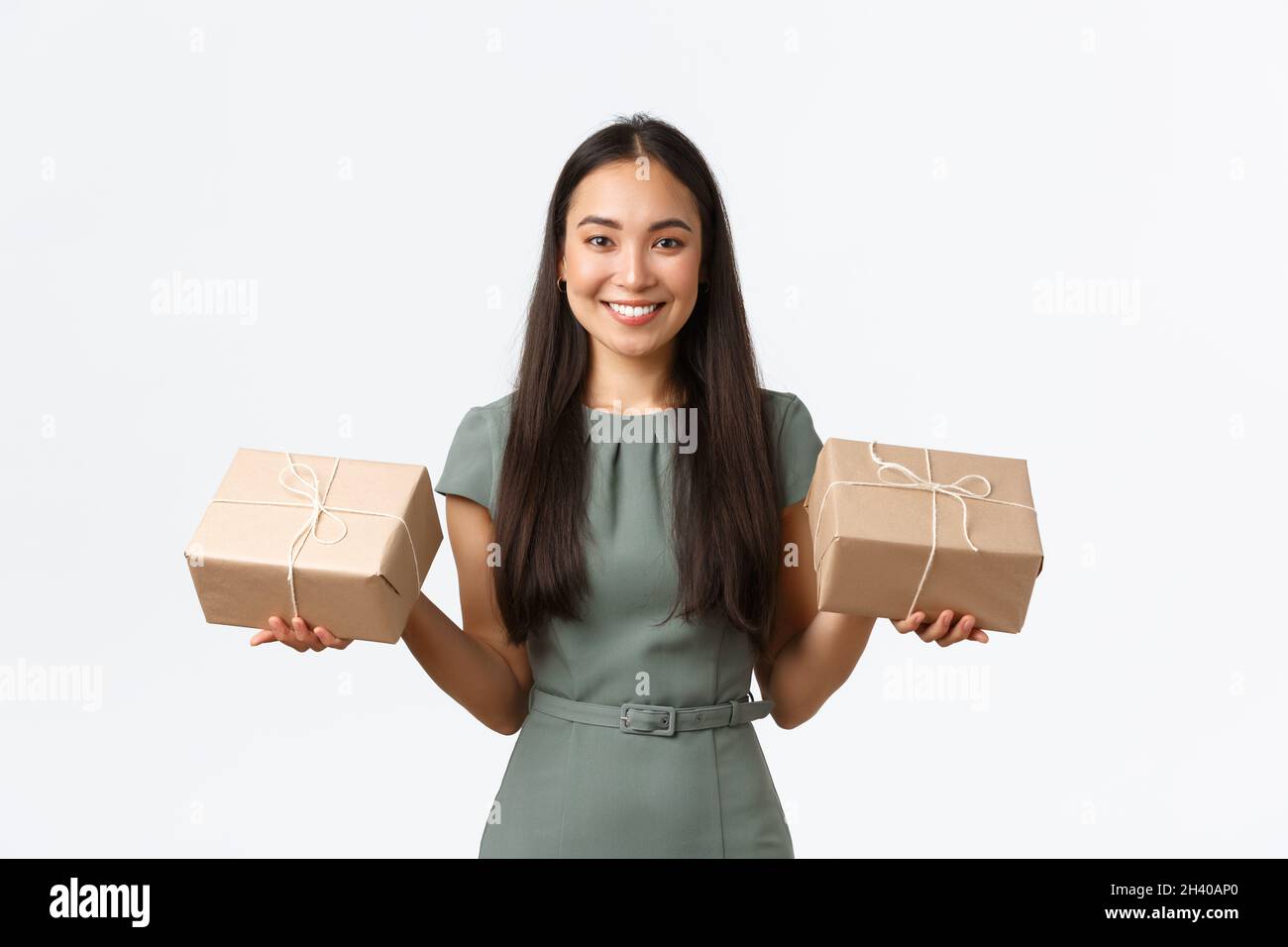 Small business owners, startup and work from home concept. Smiling asian female shop owner, packing items for shipping, holding Stock Photo