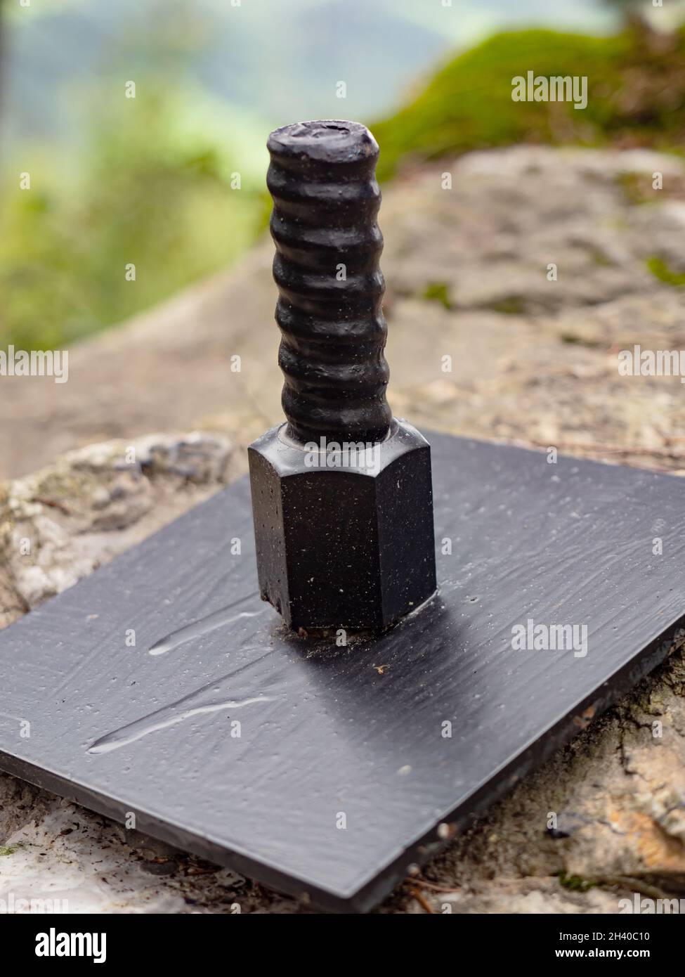 Plate and anchor bolt. Structural support on natural stone with gap to