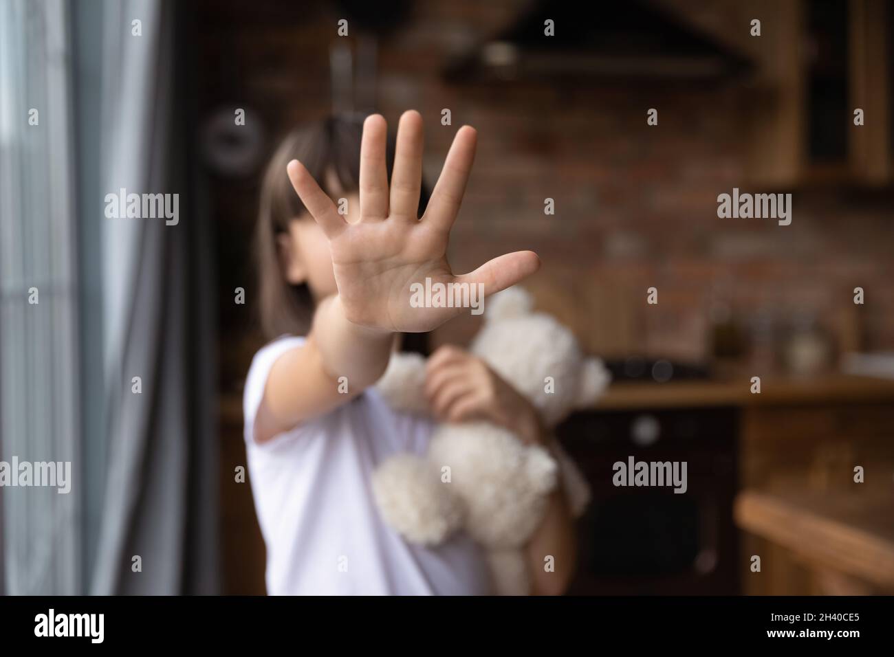 Scared little girl making no sign, showing hand stop gesture Stock Photo
