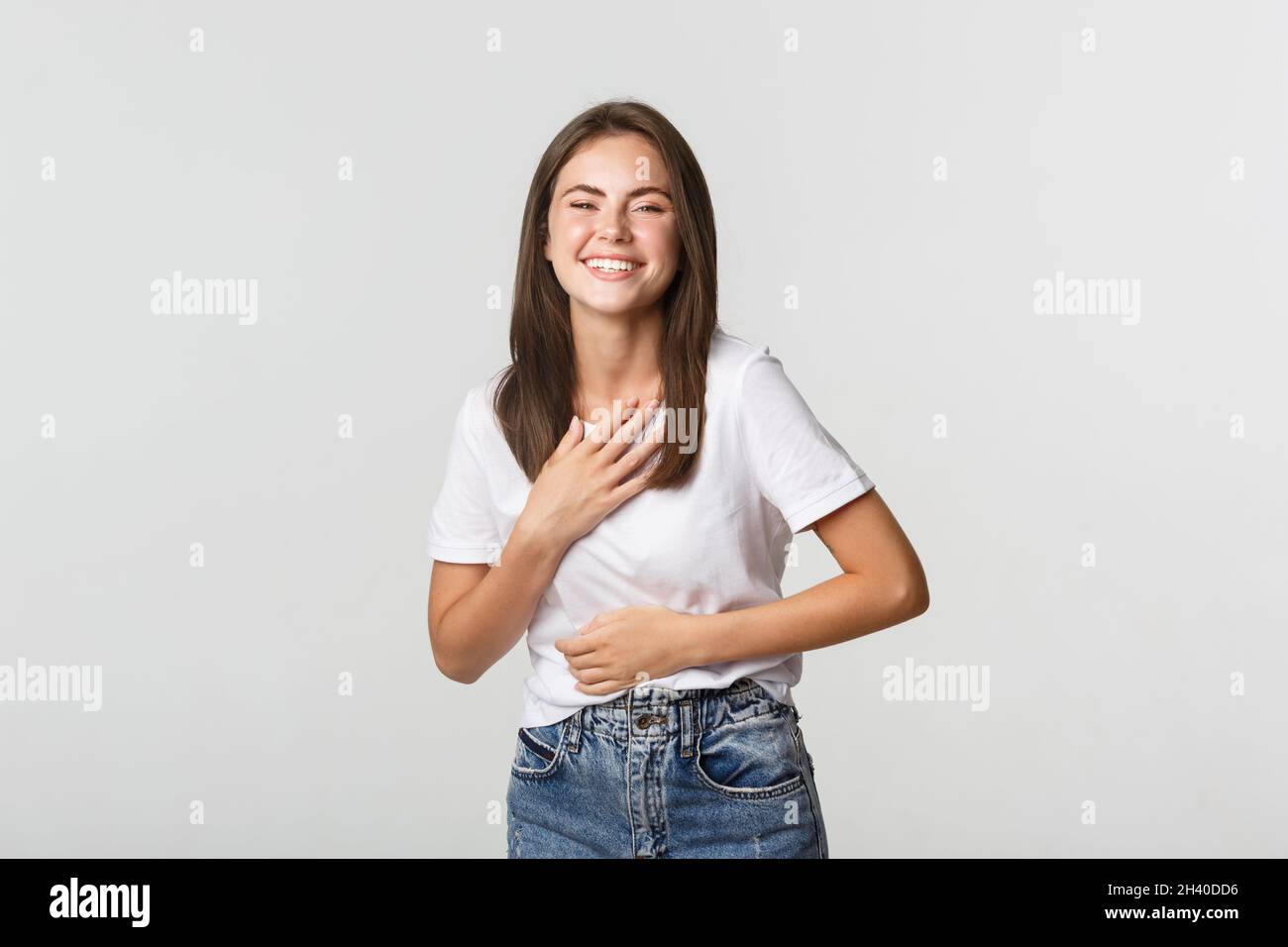 Happy beautiful girl laughing and touching chest, looking thankful Stock Photo