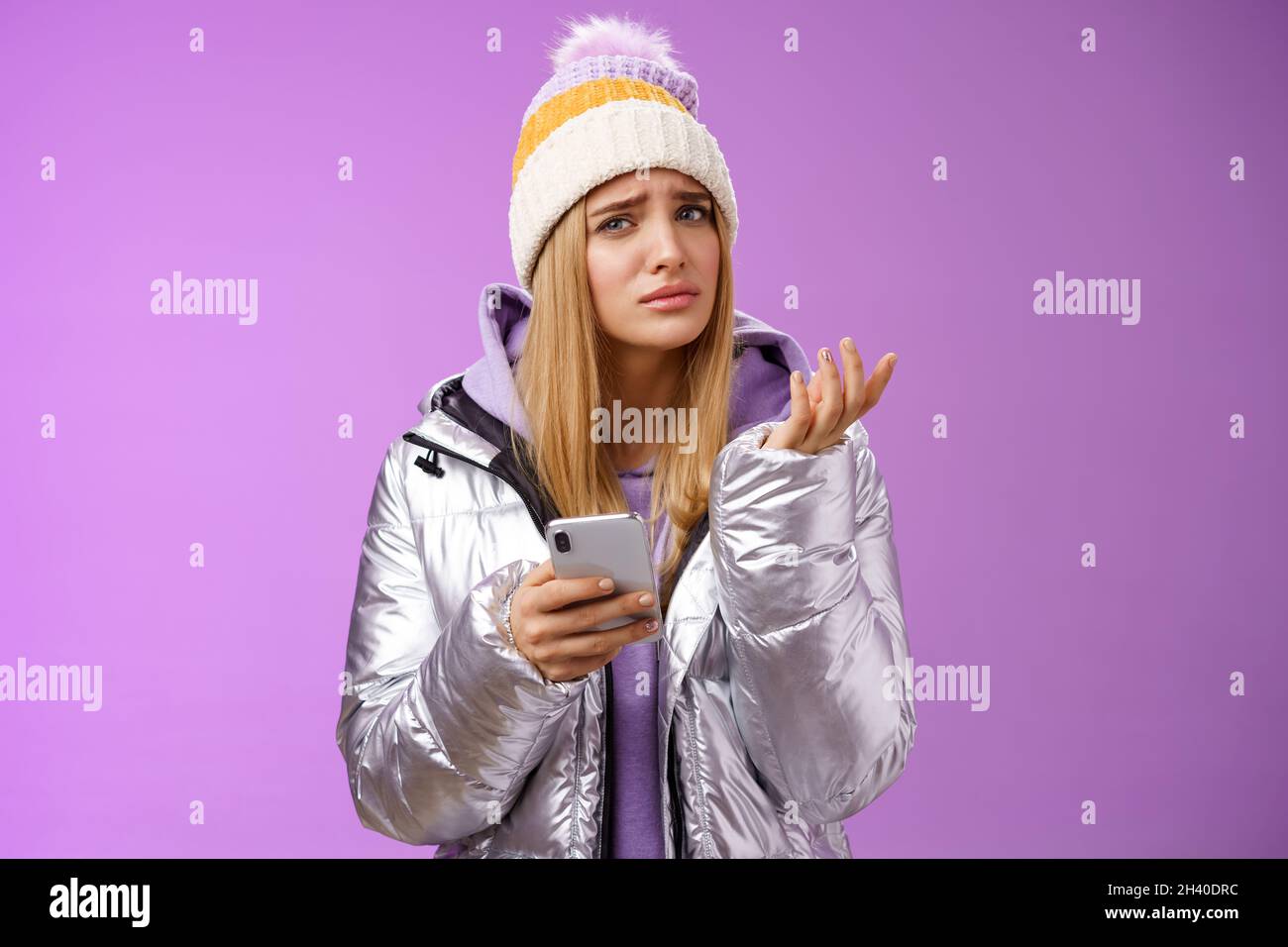 Questioned complicated cute blond girlfriend receive strange message look perplexed confused raising hand shrugging lift eyebrow Stock Photo